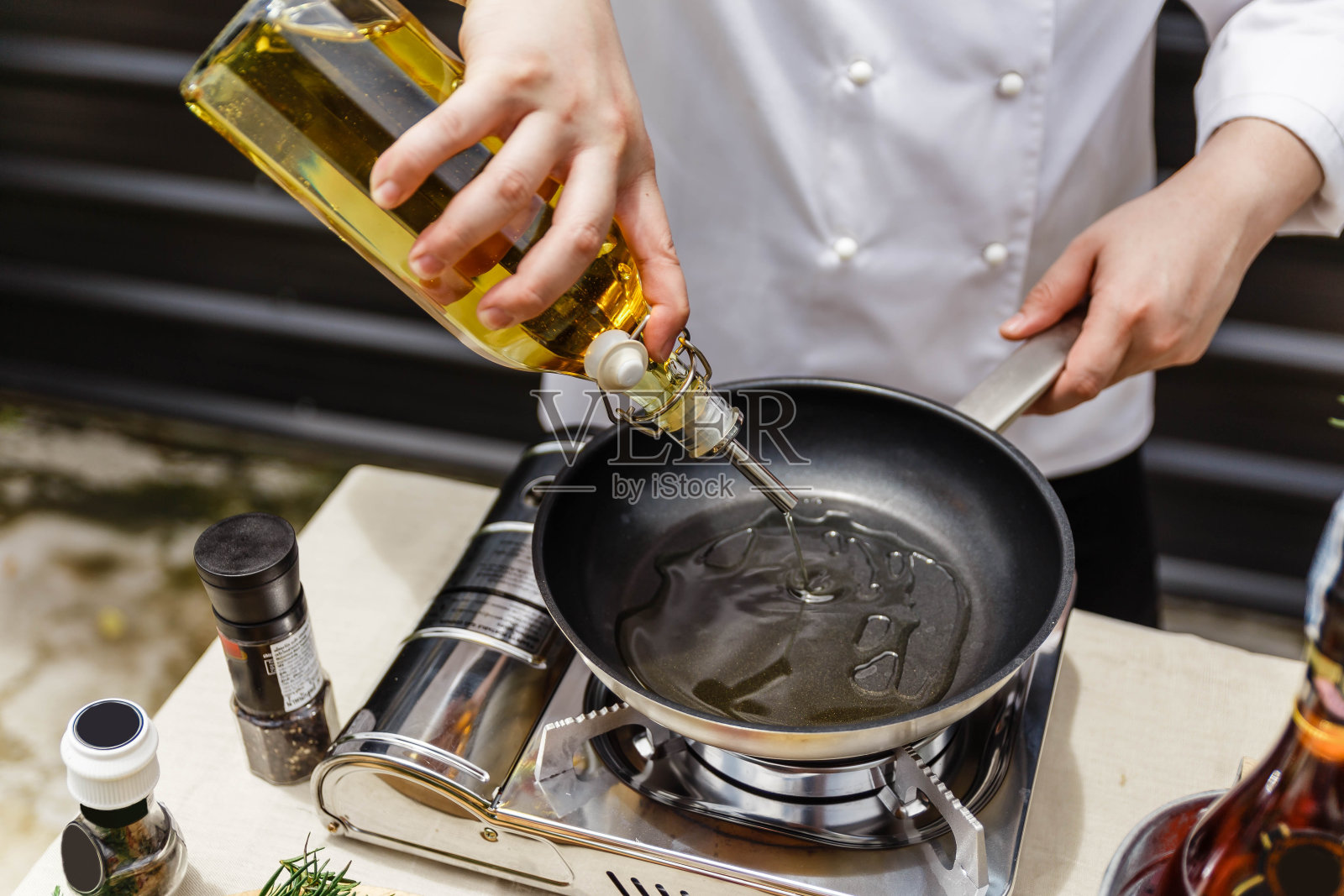 厨师用平底锅准备橄榄油。照片摄影图片