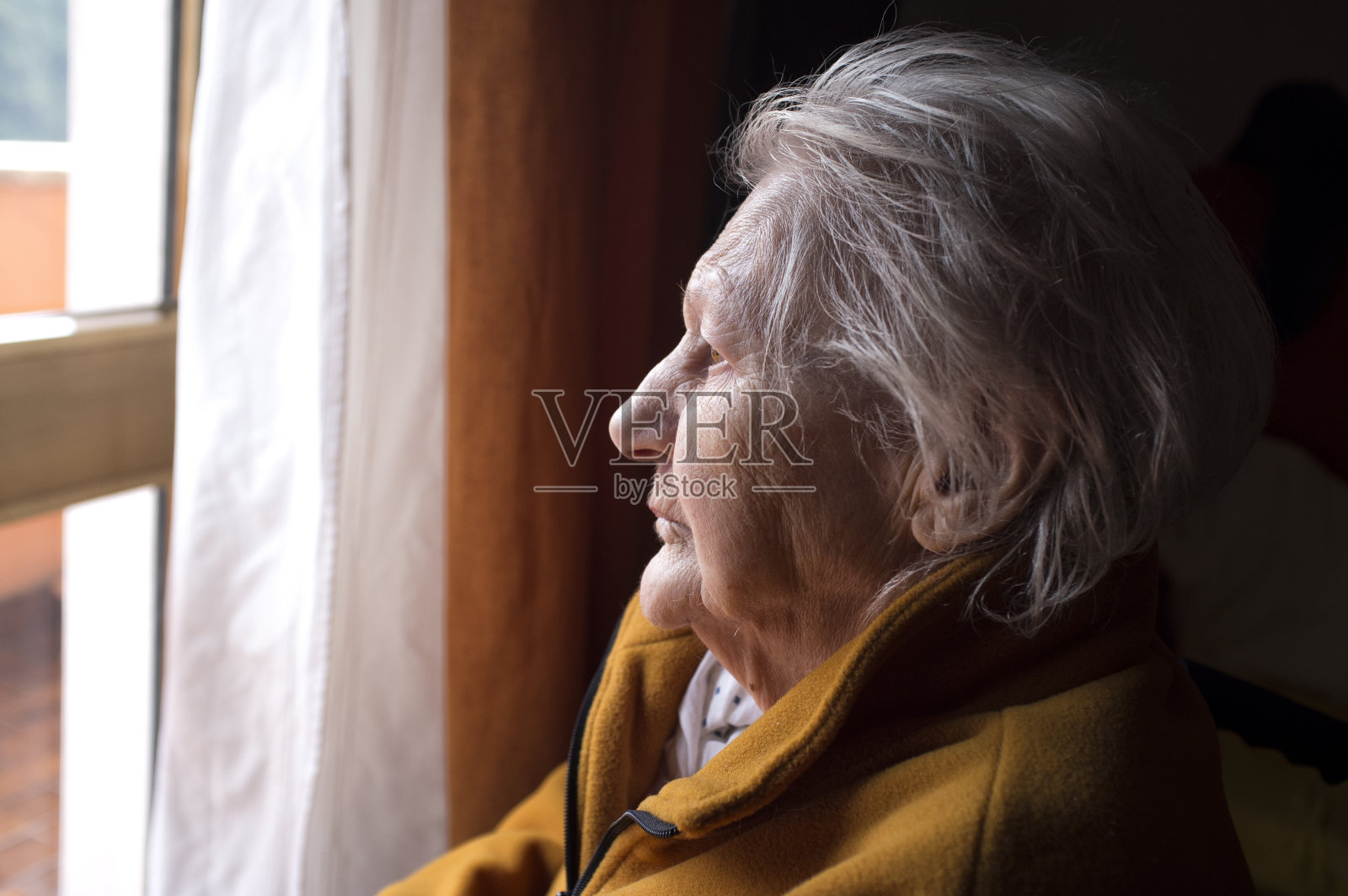 一个老妇人在看窗户照片摄影图片