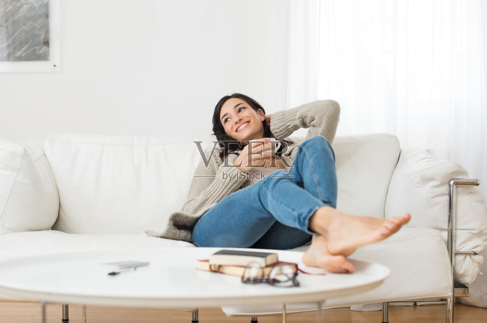 微笑的女人在沙发上思考照片摄影图片