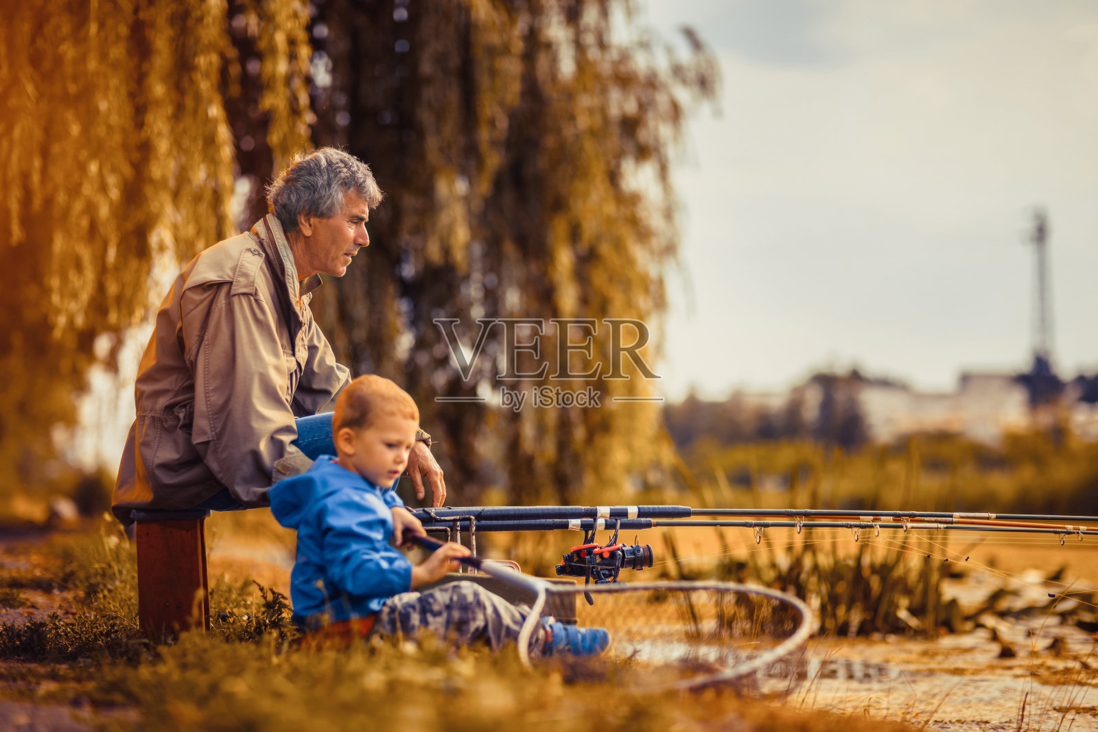 爷爷和孙子一起去钓鱼。照片摄影图片