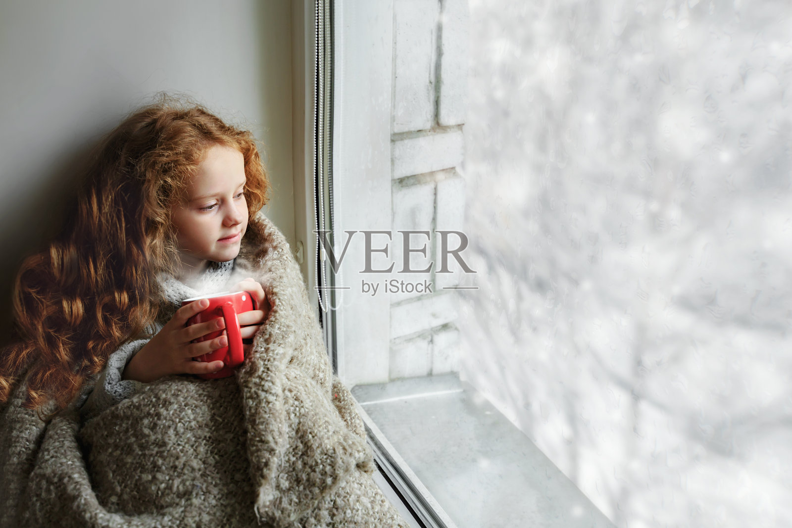 可爱的小女孩拿着杯子坐在窗边照片摄影图片