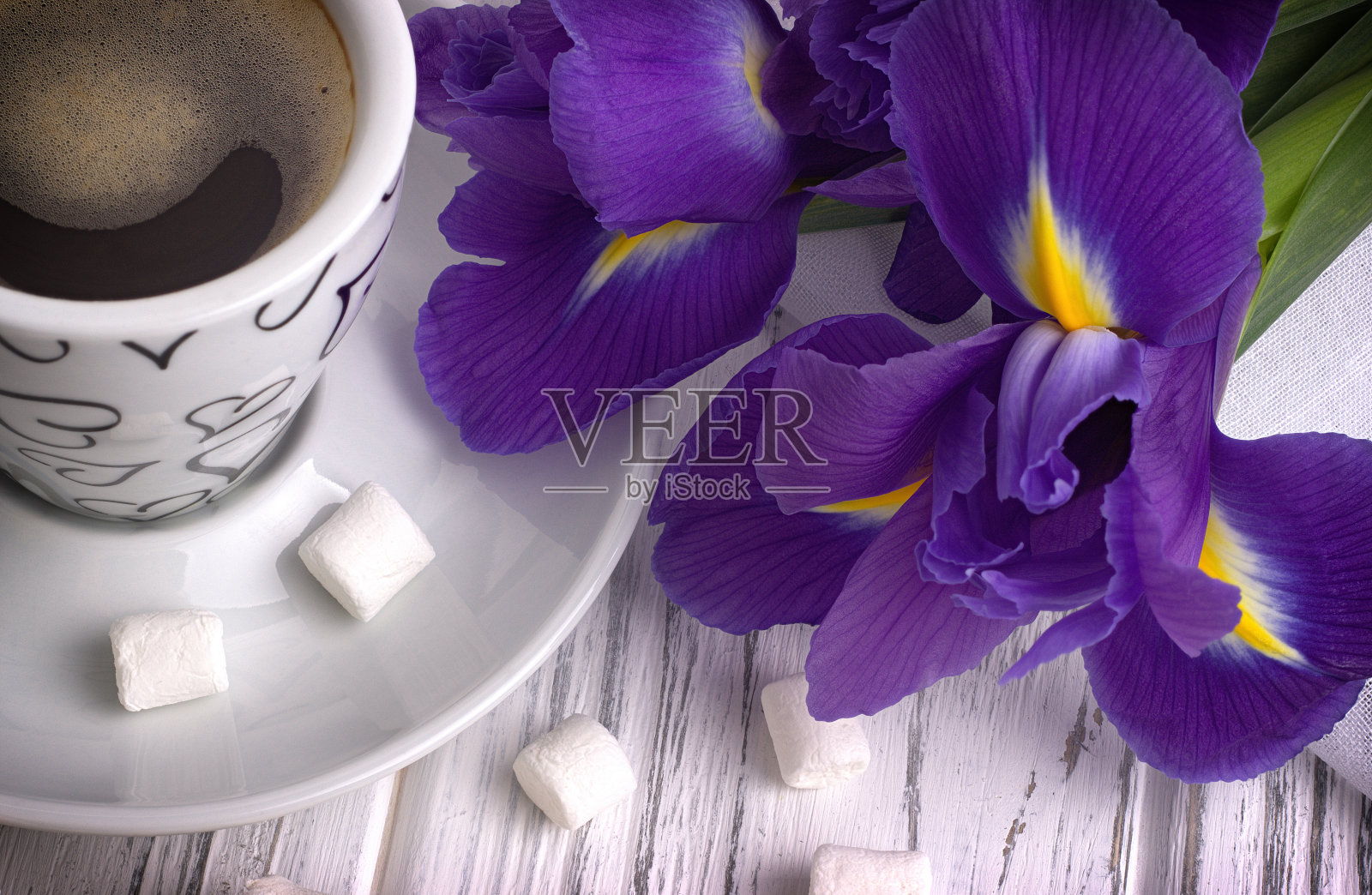 静物与一杯咖啡棉花糖鸢尾花紫色丝带在白色木制背景。照片摄影图片