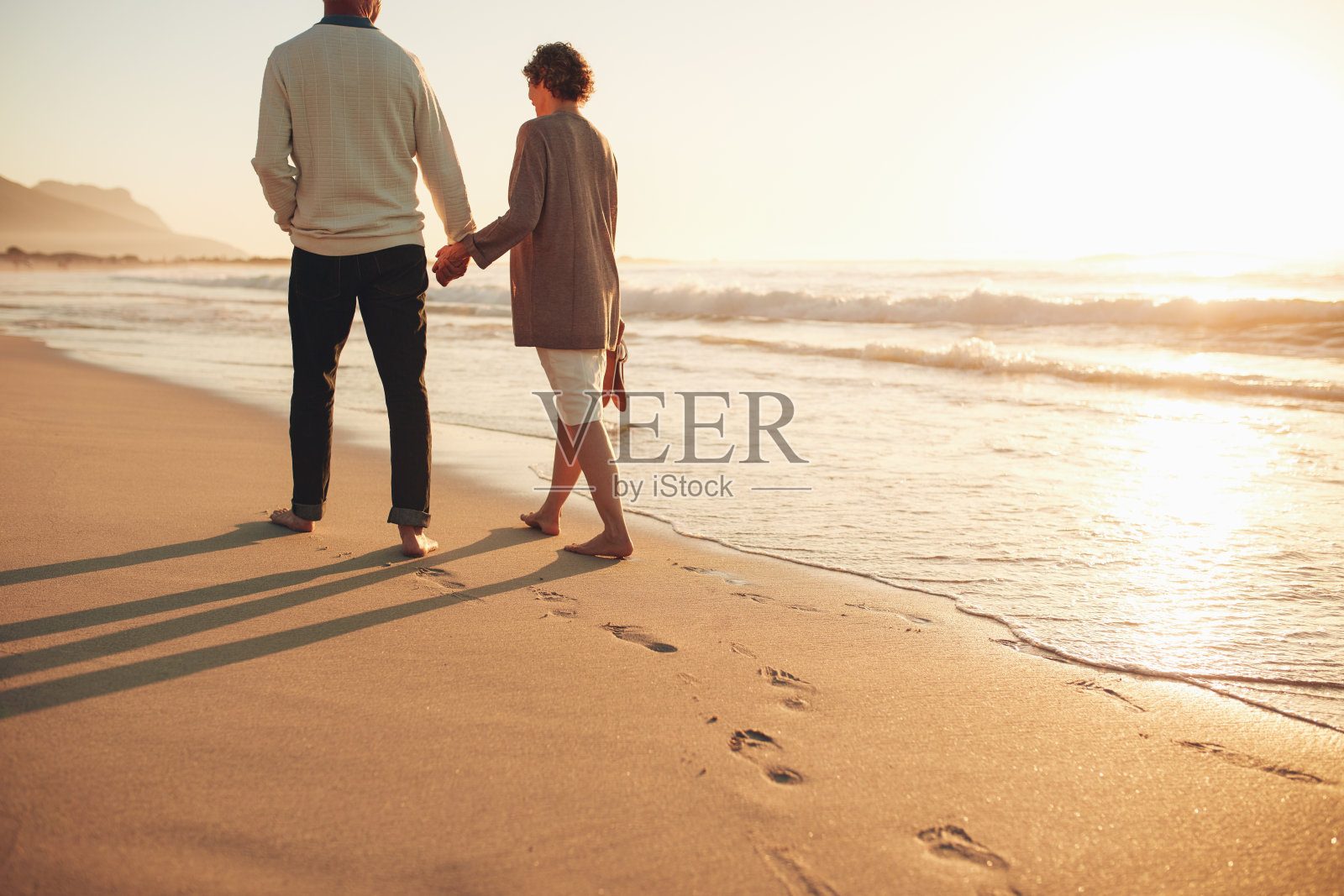一对老年夫妇在海边散步照片摄影图片
