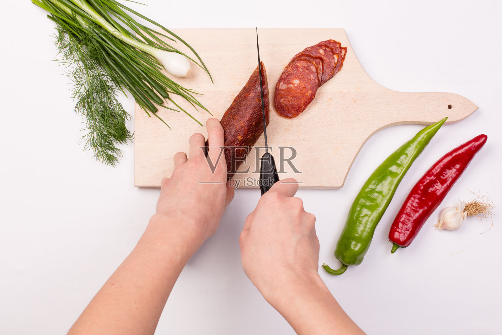 女性用手切红香肠片照片摄影图片