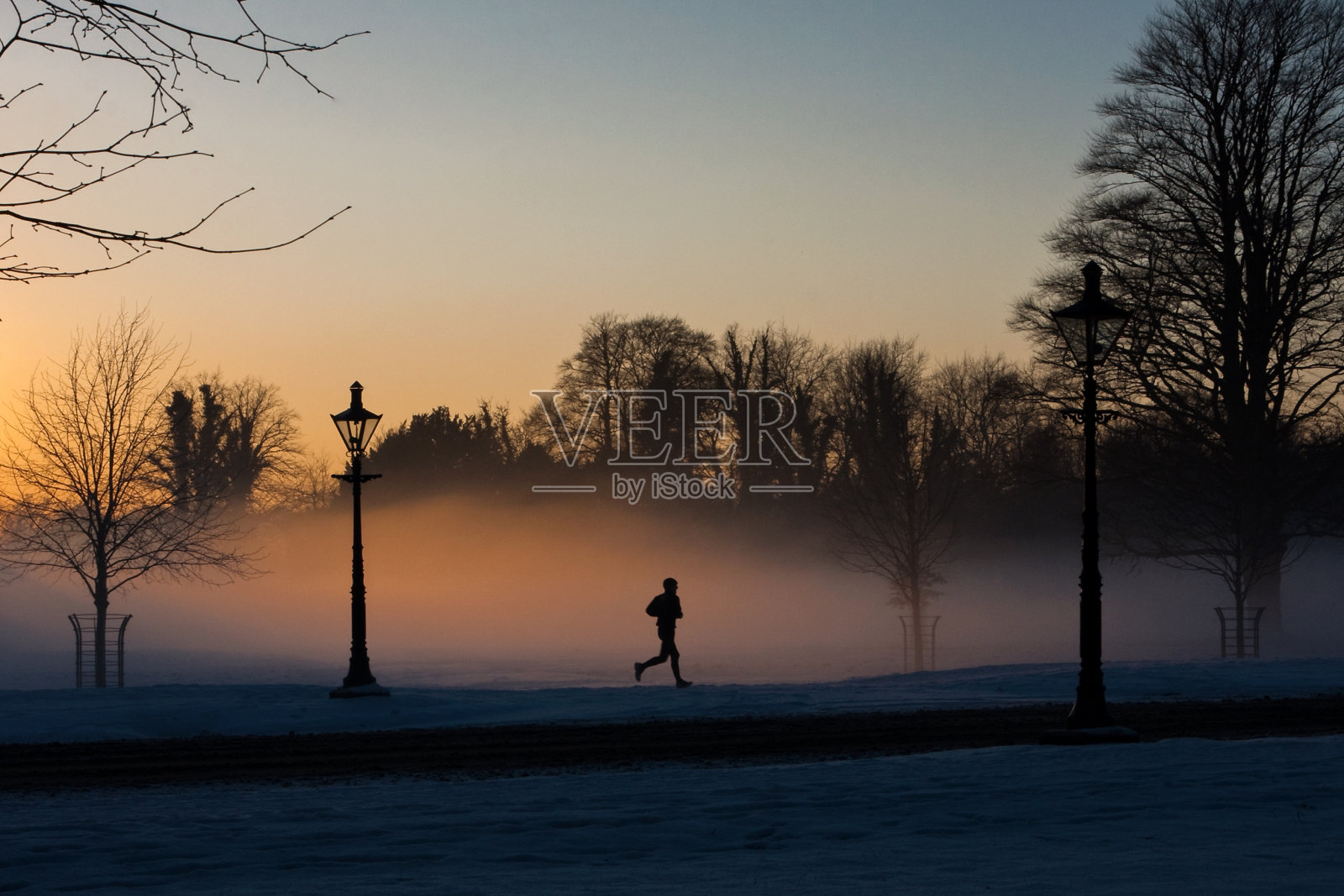 雾蒙蒙的凤凰公园里的跑步者。照片摄影图片