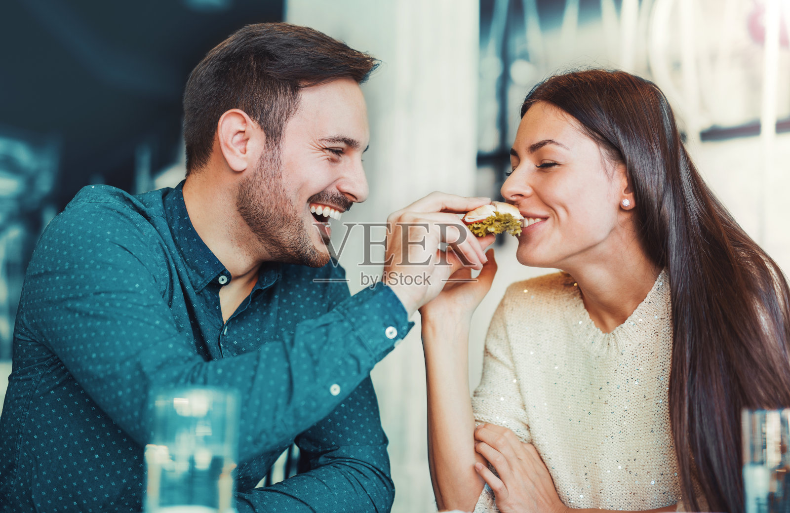 一对年轻漂亮的夫妇坐在咖啡馆里吃早餐照片摄影图片