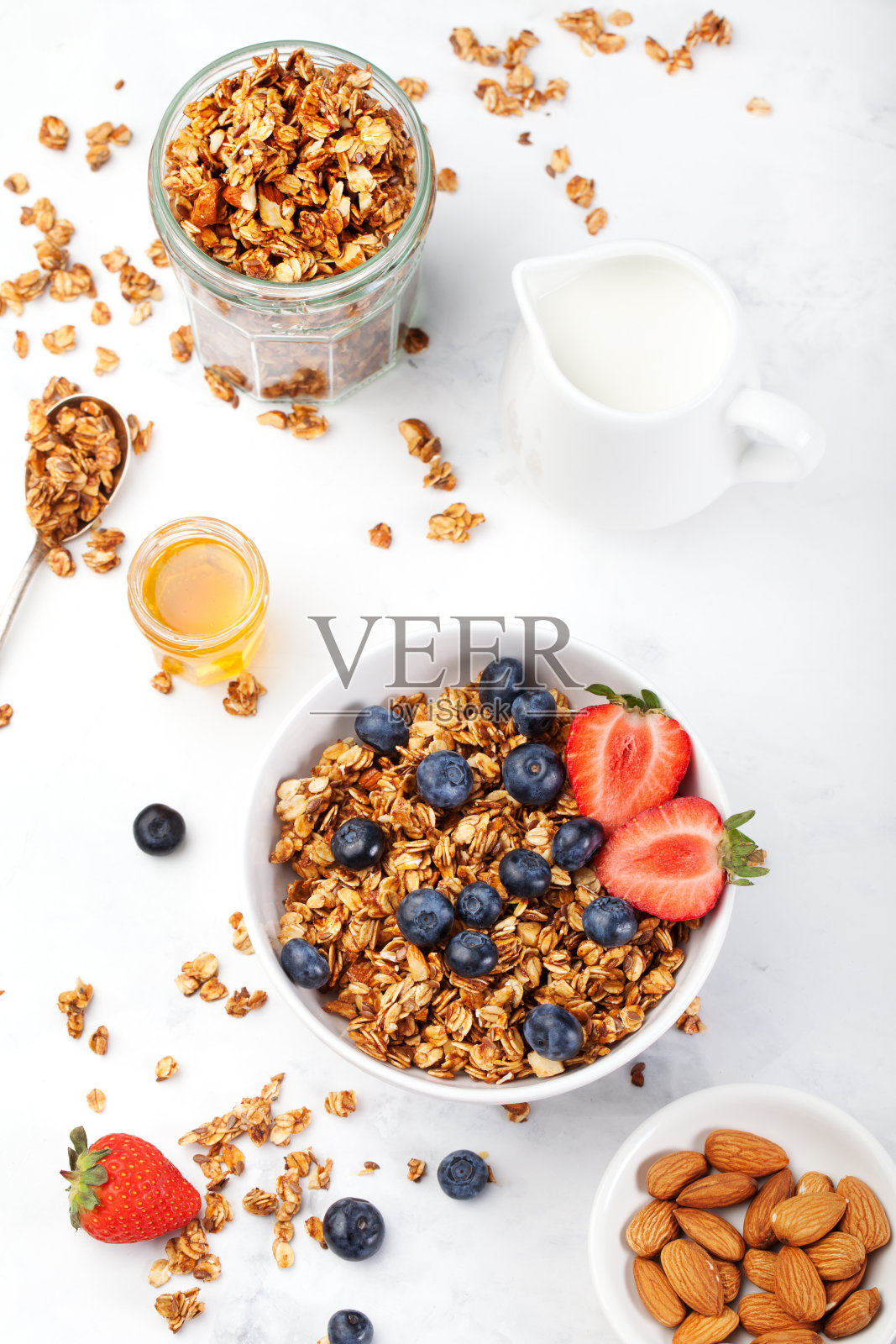 健康早餐格兰诺拉麦片，碗里的牛奶和浆果照片摄影图片