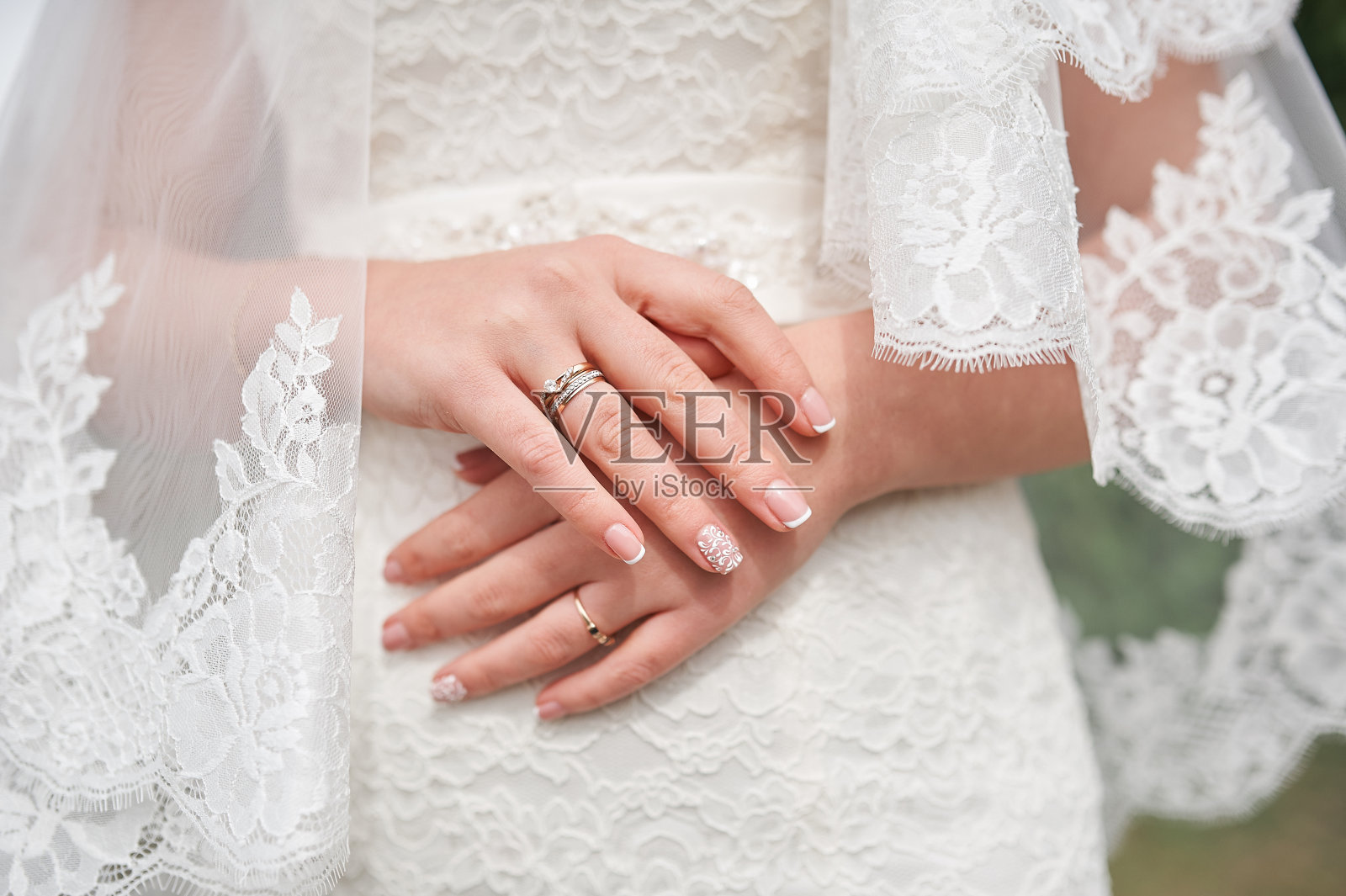 双手的新娘在白色的礼服与美甲婚礼的日子照片摄影图片