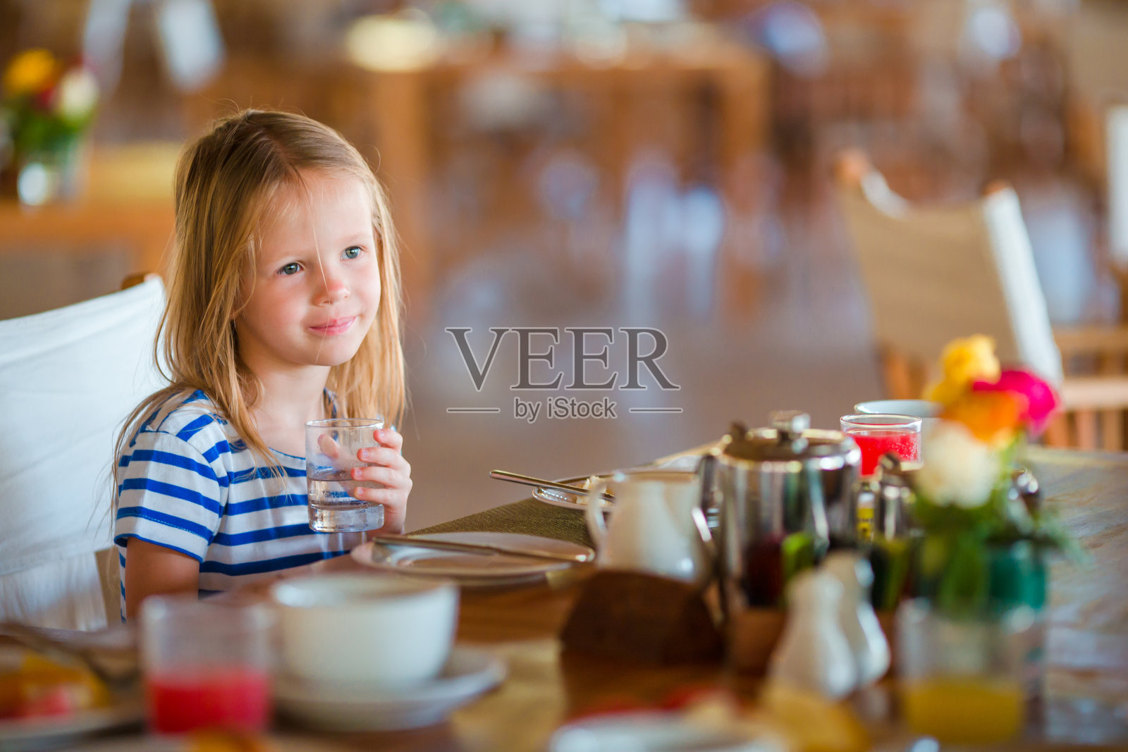 可爱的小女孩在度假餐厅吃早餐照片摄影图片