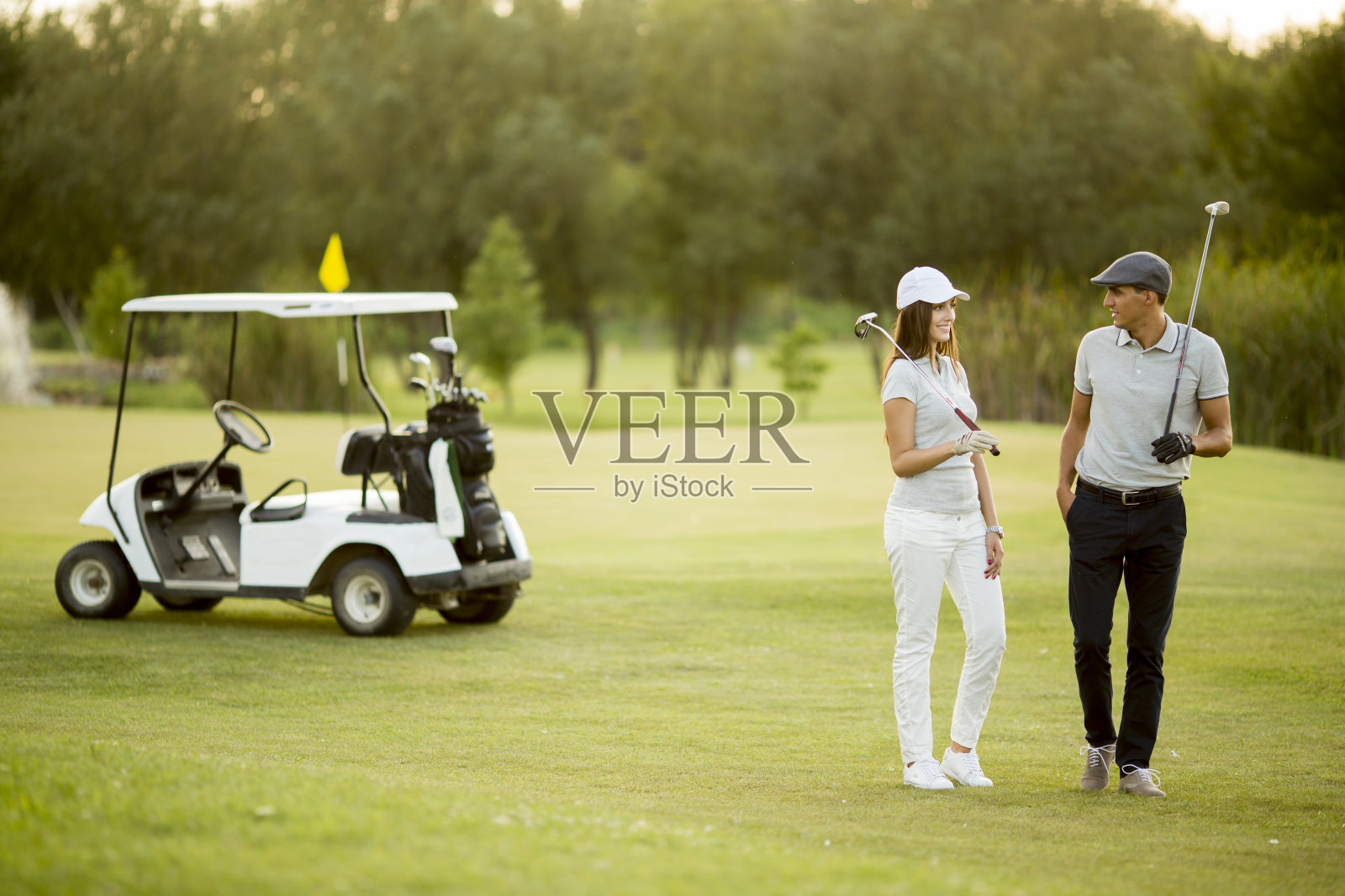 年轻夫妇在高尔夫球车上照片摄影图片