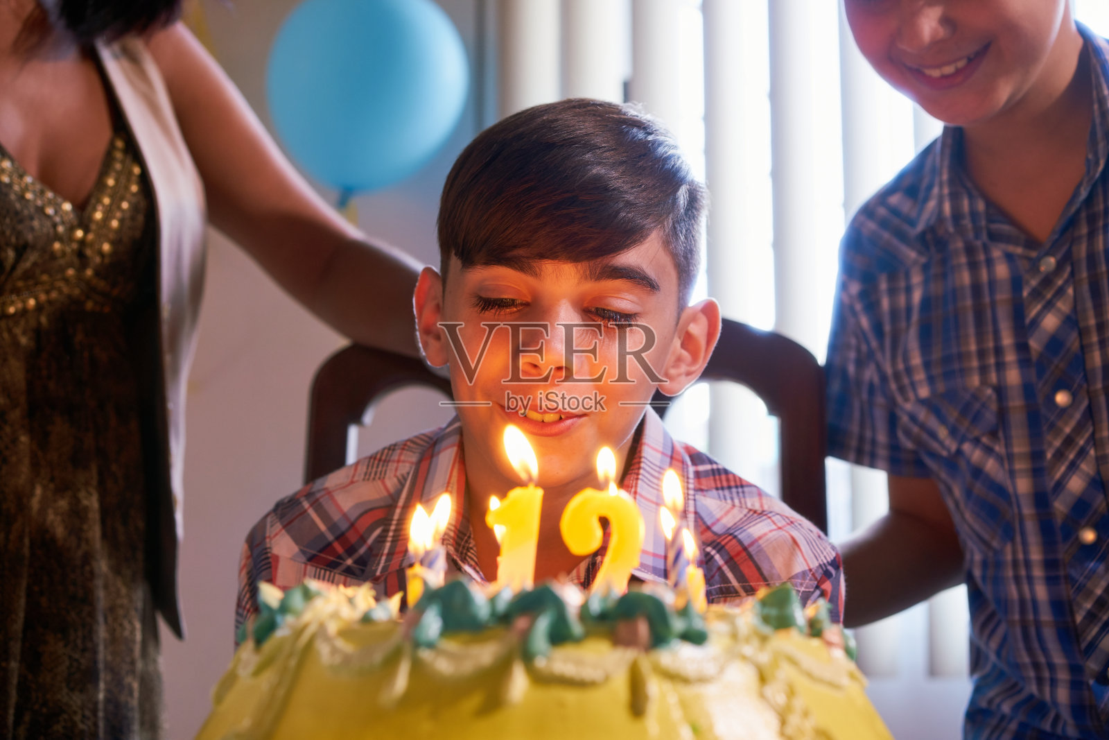 生日派对与快乐拉丁男孩吹蜡烛蛋糕照片摄影图片