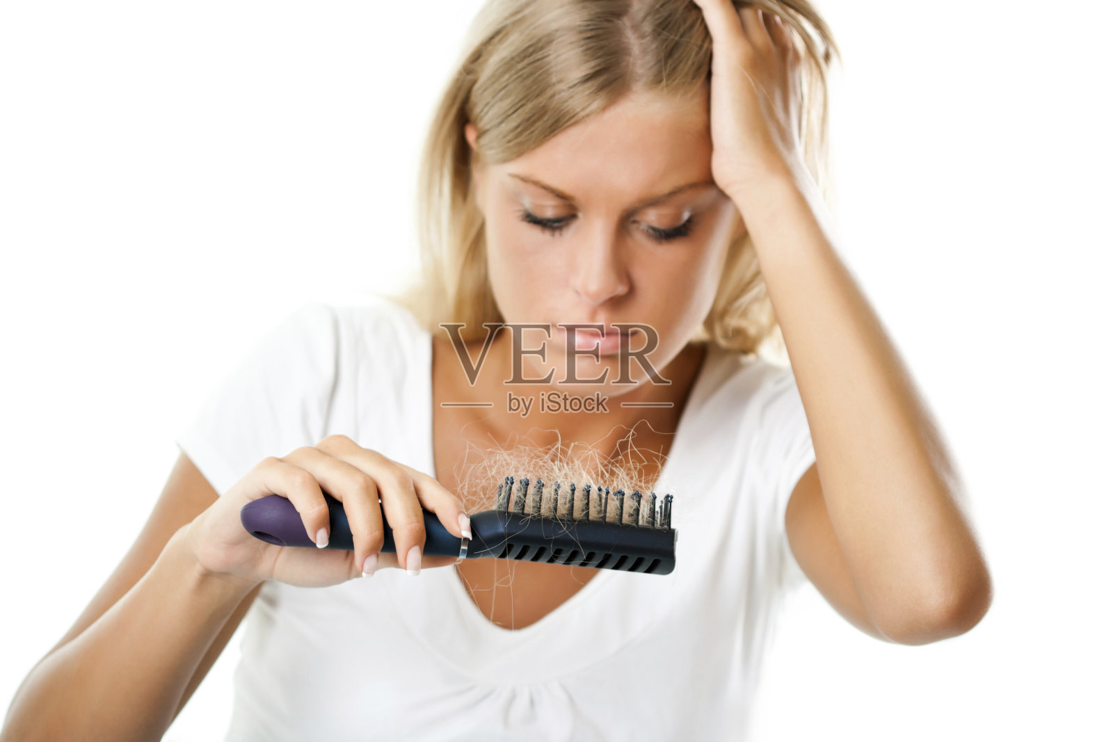 一个女人拿着她的头发检查她的梳子照片摄影图片