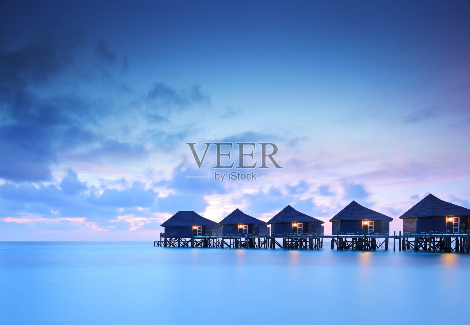 日落时分马尔代夫岛上的水别墅照片摄影图片