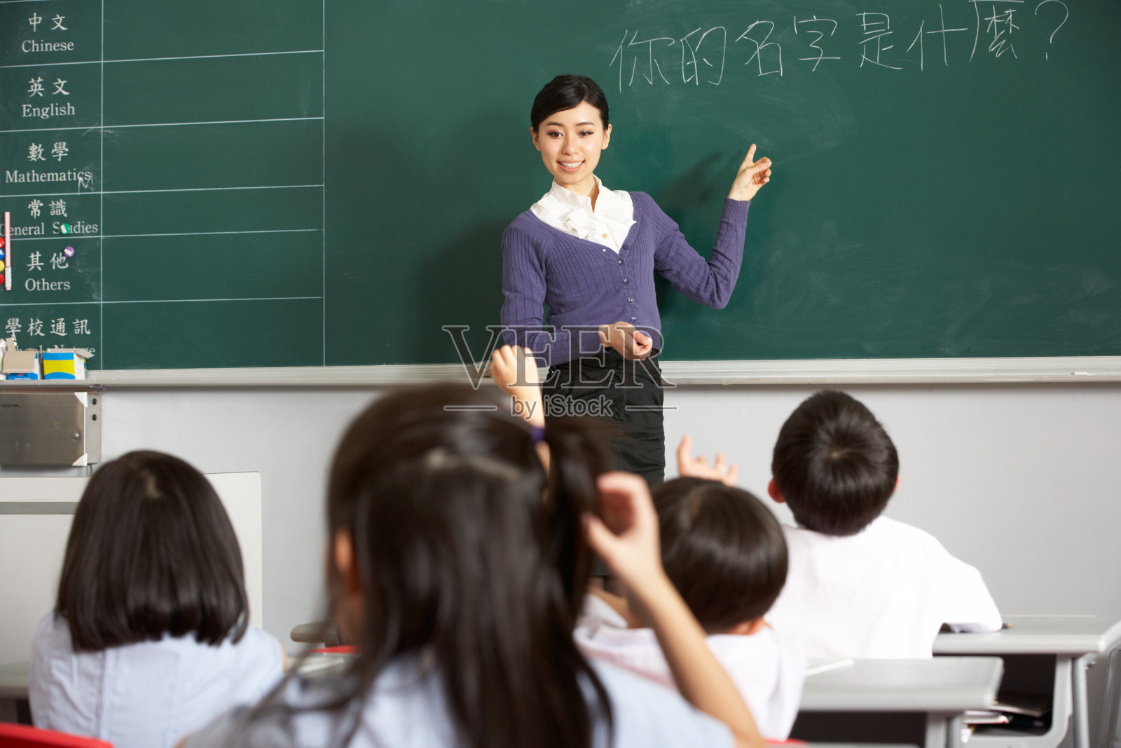 中文学校教室里，老师站在黑板旁照片摄影图片