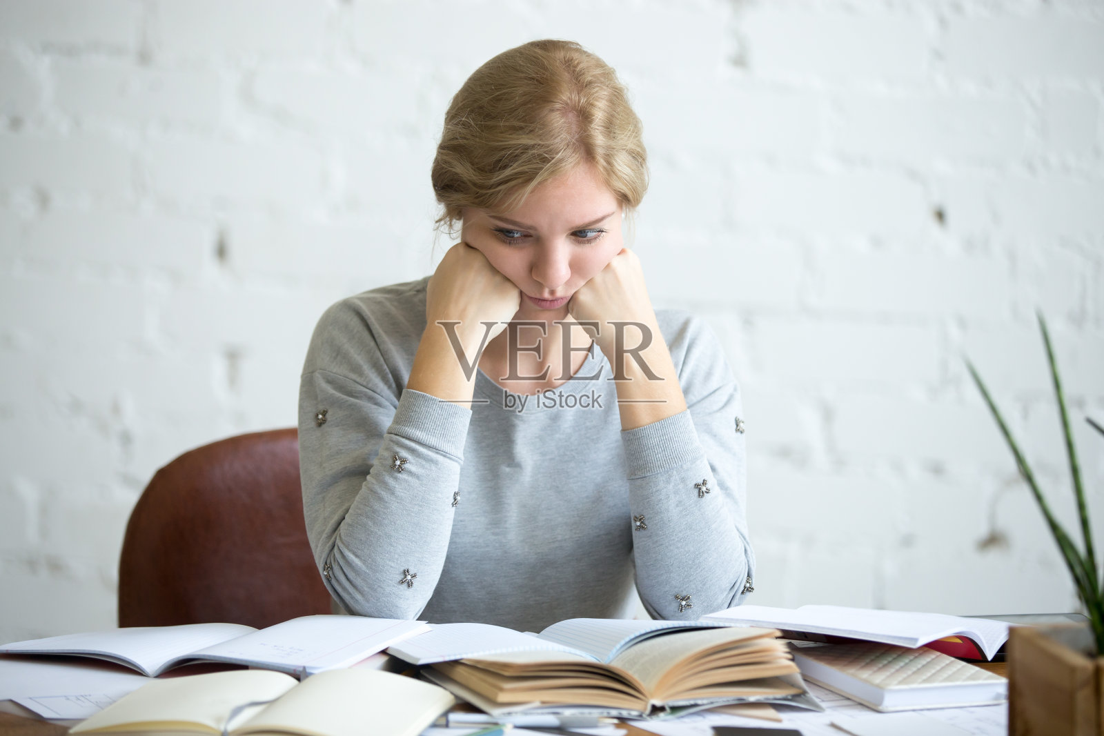 一个疲惫的女学生坐在课桌前照片摄影图片