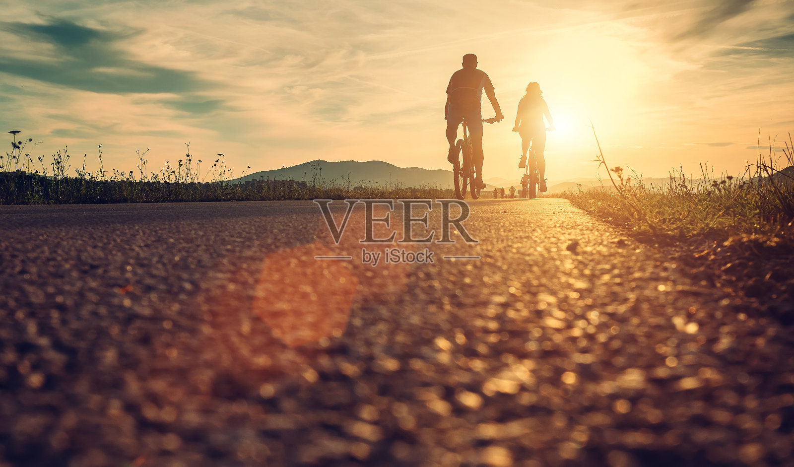 骑自行车的人在日落大道上照片摄影图片