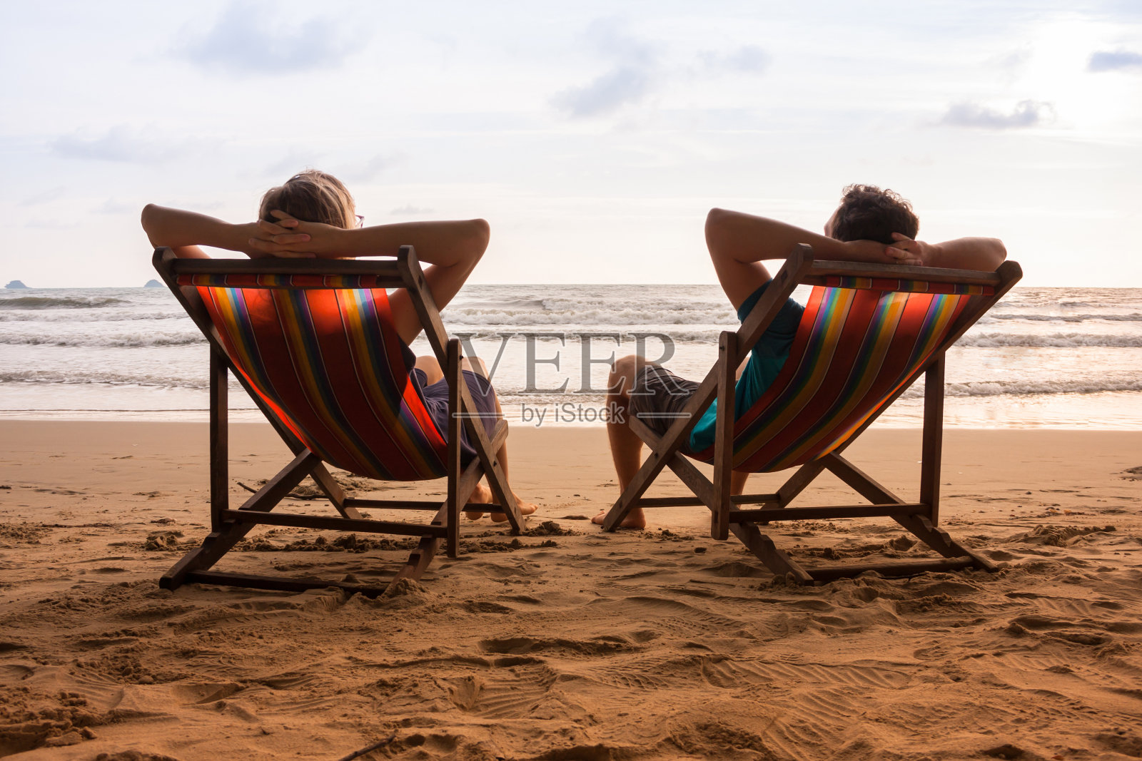一对夫妇坐在海边的躺椅上照片摄影图片