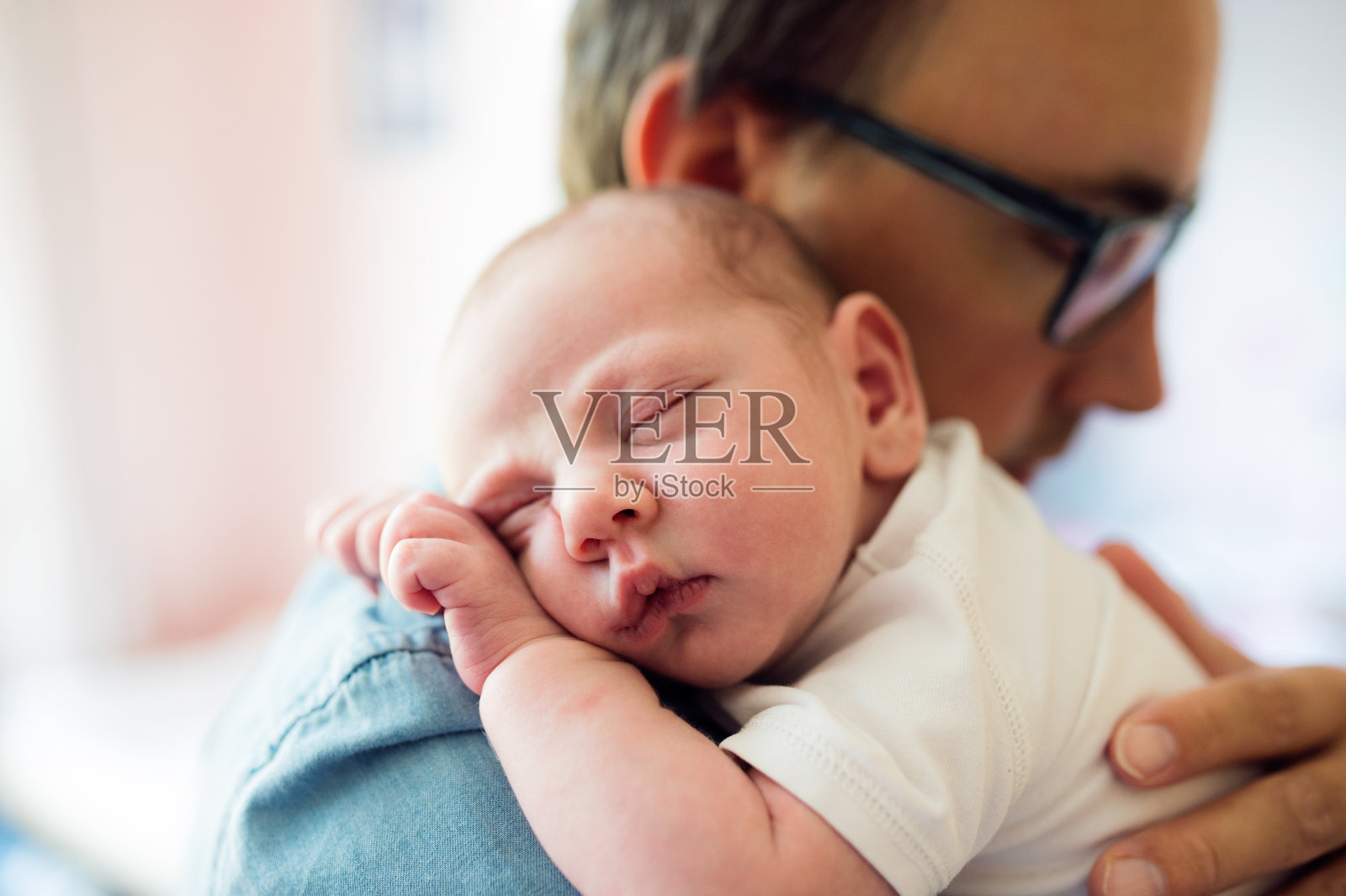 年轻的父亲抱着他刚出生的儿子的特写照片摄影图片