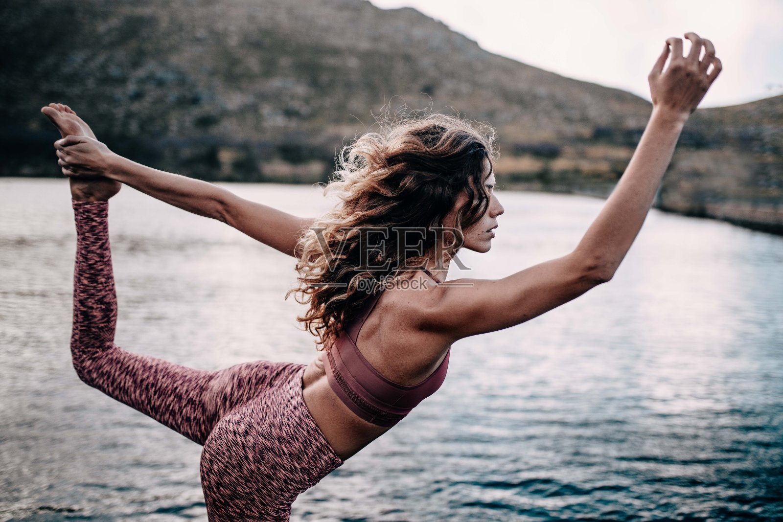 美丽的年轻女性成年人做瑜伽姿势在湖照片摄影图片
