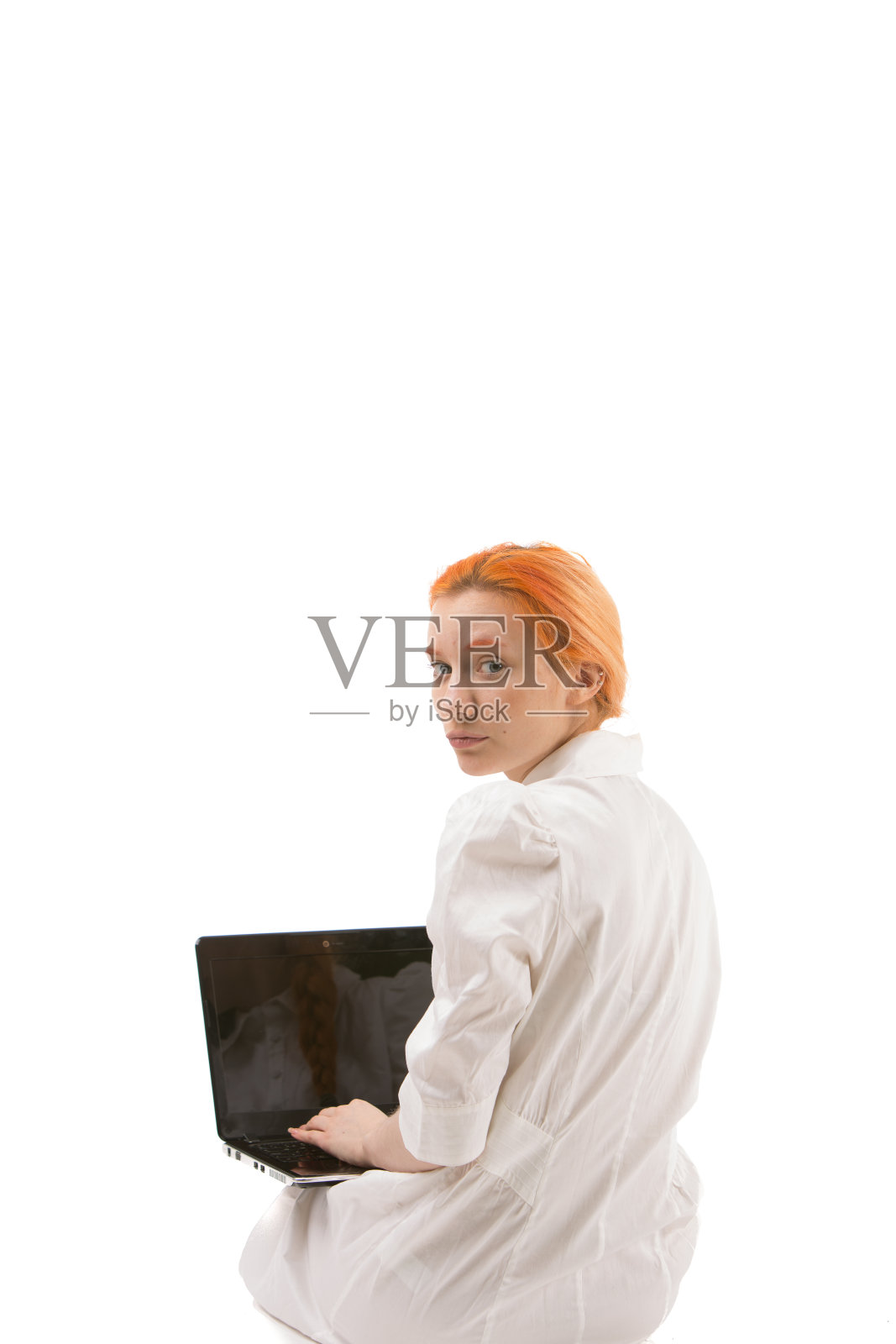一个红发女孩在用笔记本电脑照片摄影图片