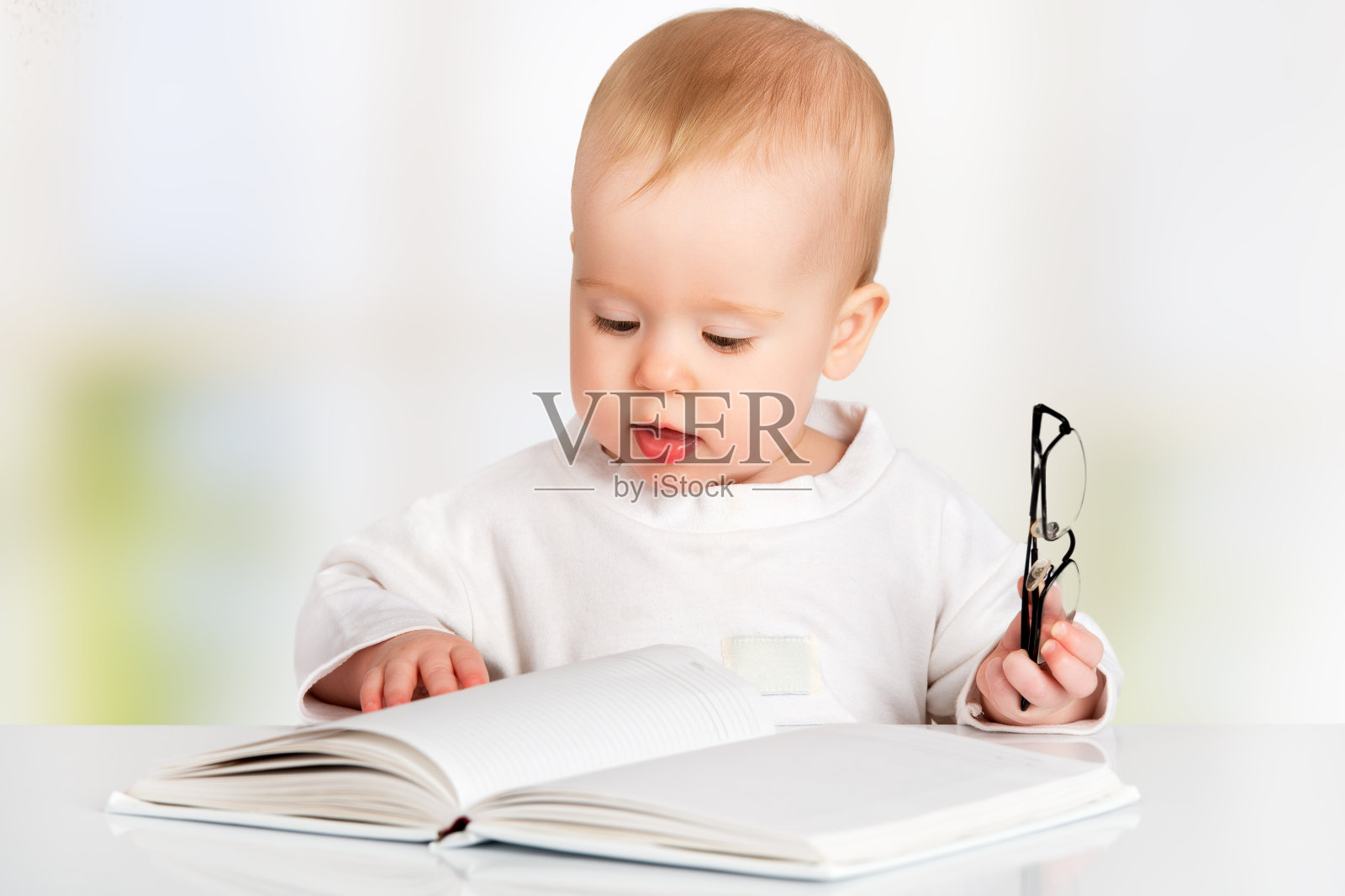有趣的婴儿在读一本书照片摄影图片