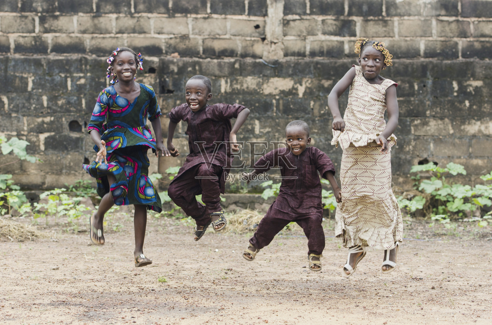 四个非洲儿童在户外玩耍，跳得尽可能高照片摄影图片