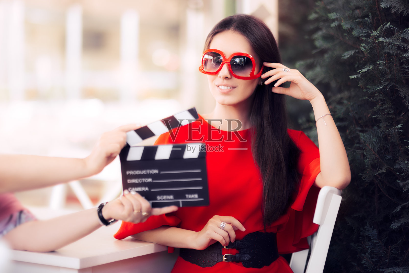 快乐的女演员戴着超大墨镜拍摄电影场景照片摄影图片