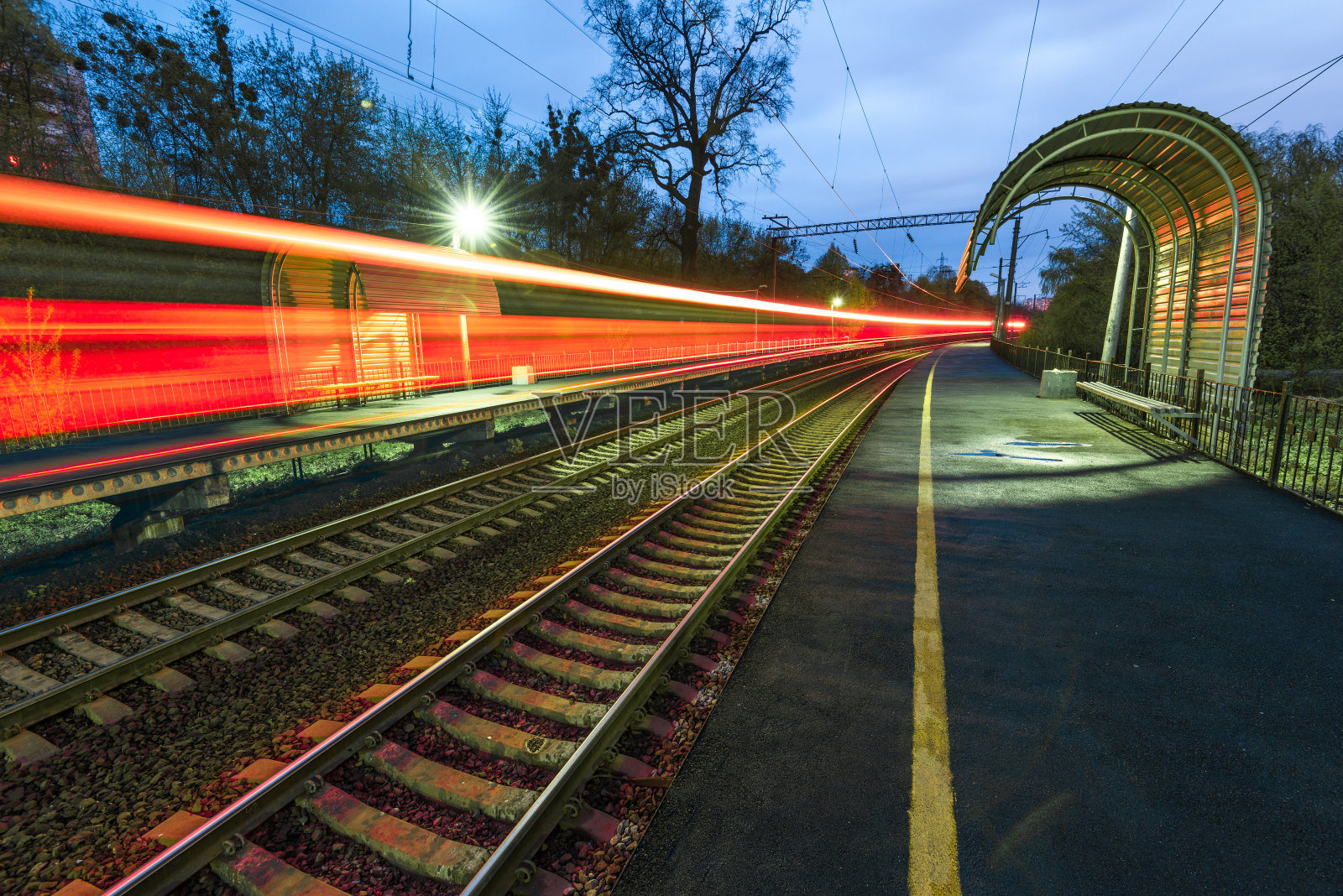 夜间高速列车的运动模糊显示灯光轨迹照片摄影图片