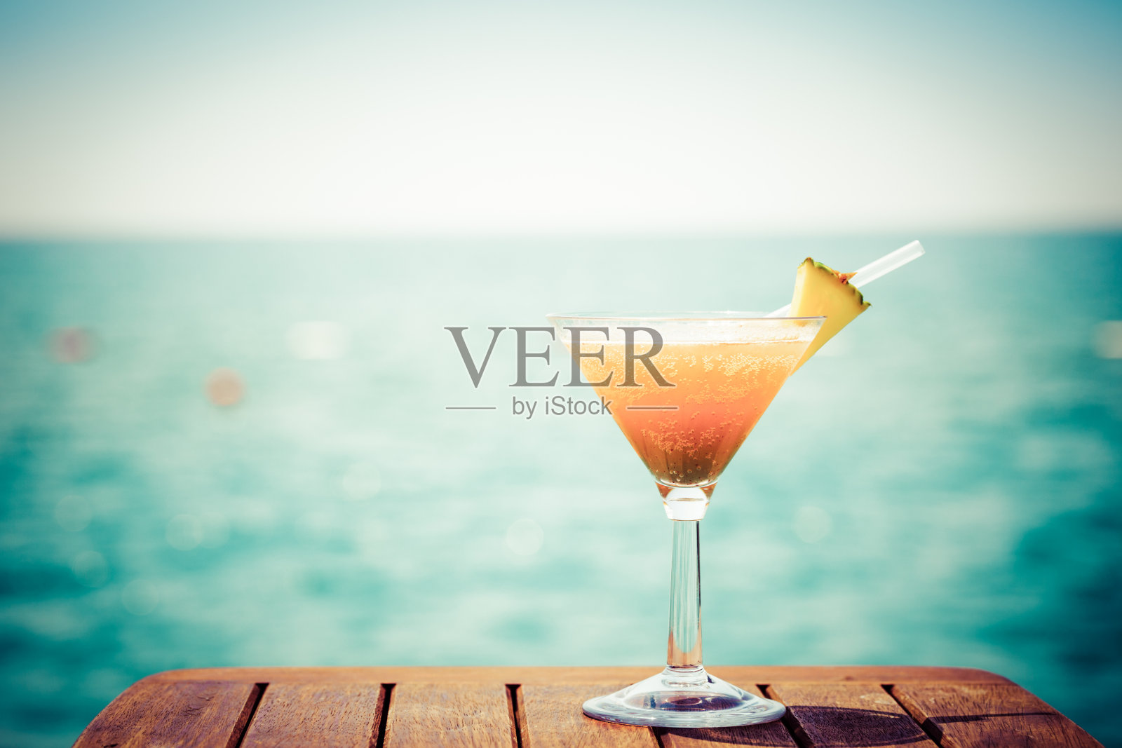 热带度假的概念。码头上的异国鸡尾酒。豪华度假背景。橙色鸡尾酒和海景照片摄影图片