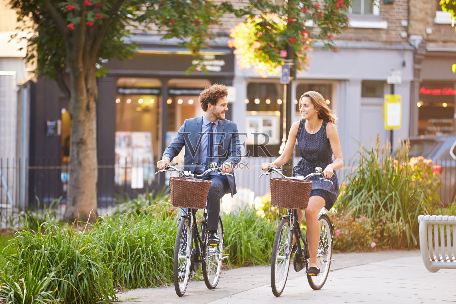 快乐的商业人士骑着自行车穿过城市公园照片摄影图片