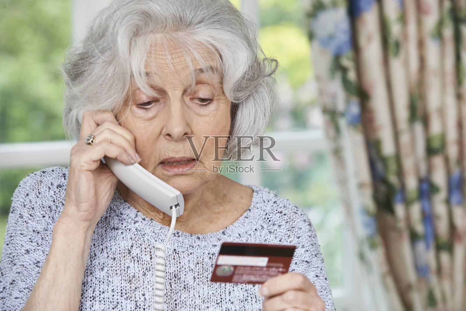 在电话里提供信用卡信息的资深女性照片摄影图片
