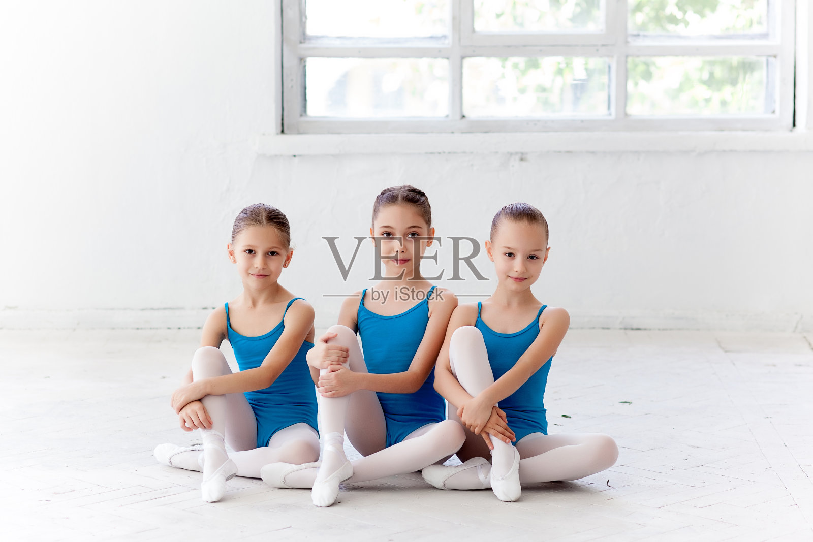 三个芭蕾舞小女孩坐在一起摆姿势照片摄影图片