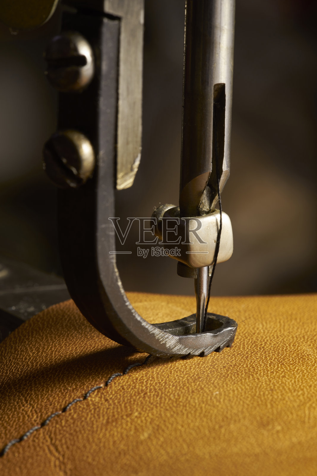 缝纫机工作部分与皮革的特写照片摄影图片