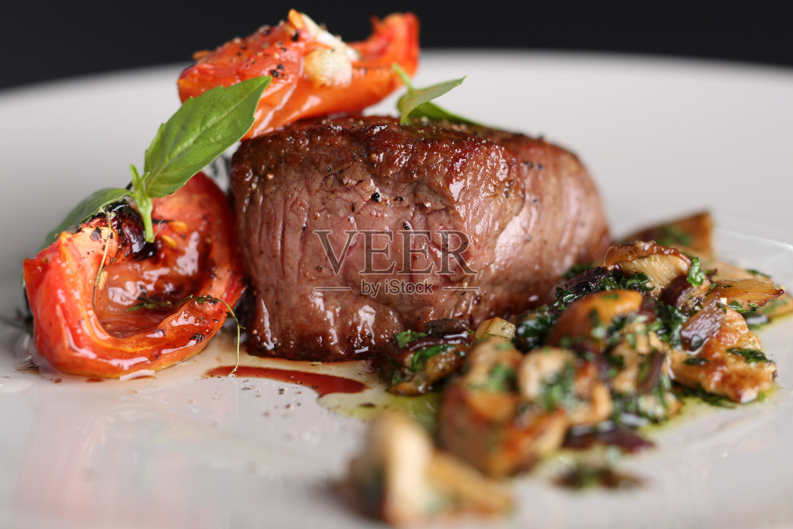 烤肉，西红柿和蘑菇放在白色的盘子里照片摄影图片