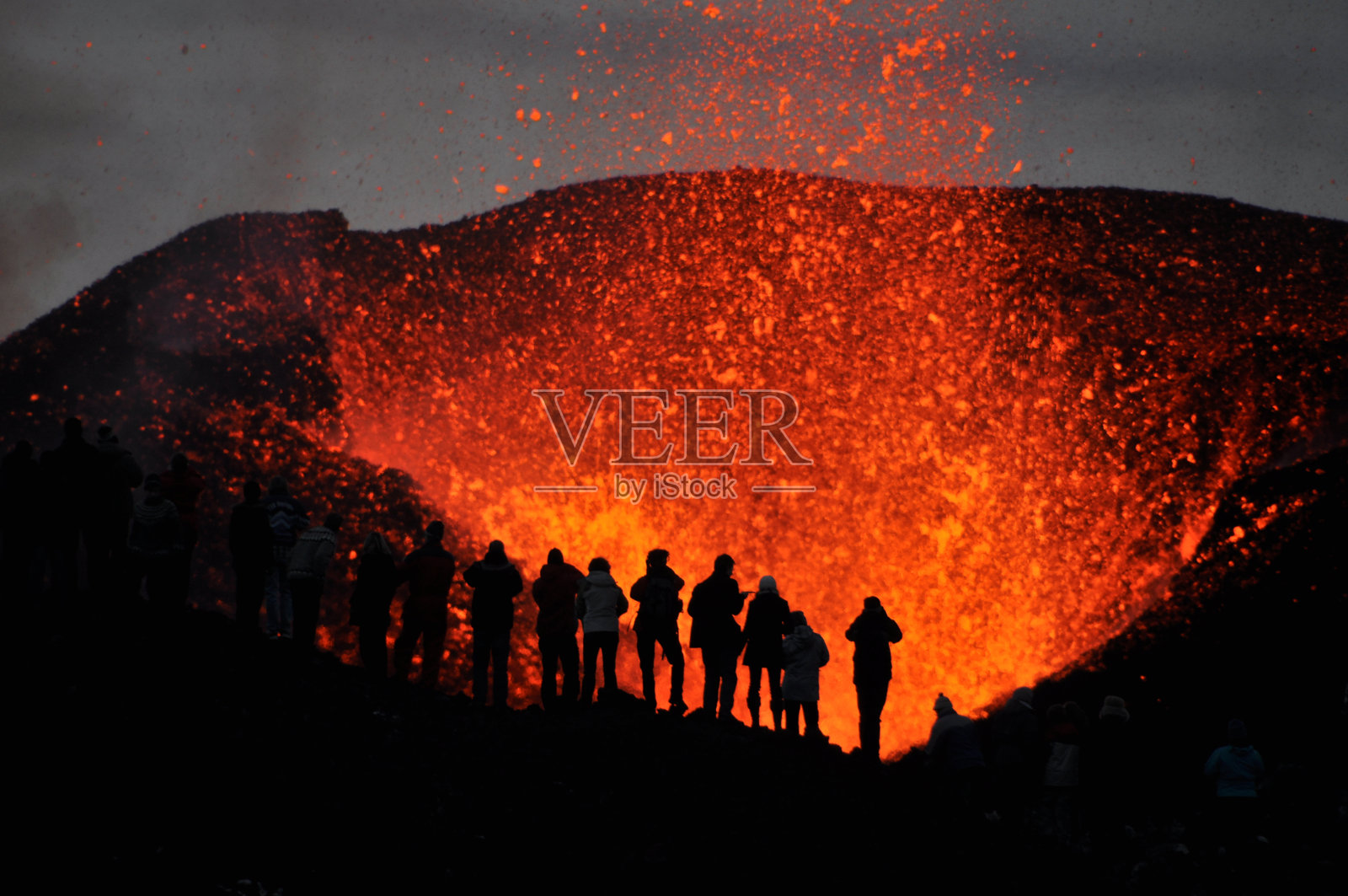 见证火山爆发的冒险者照片摄影图片