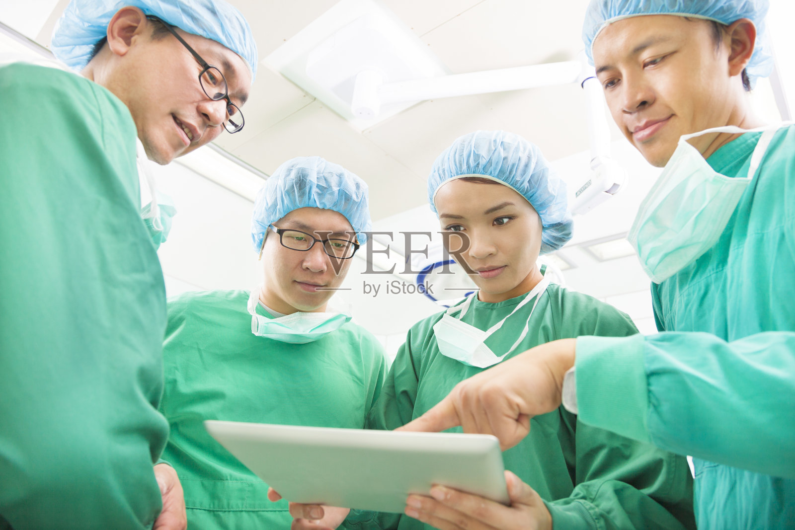 外科医生用片剂讨论手术过程照片摄影图片