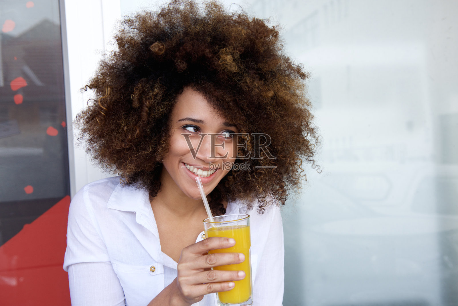 微笑的年轻非洲妇女在户外咖啡馆喝果汁照片摄影图片