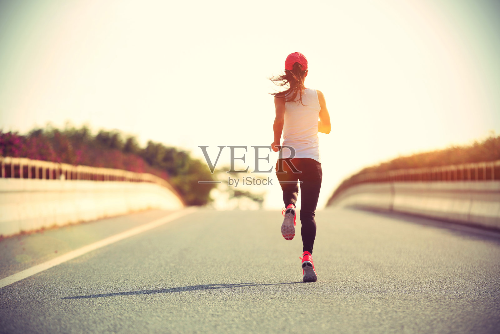 年轻的女运动员在城市的道路上跑步照片摄影图片