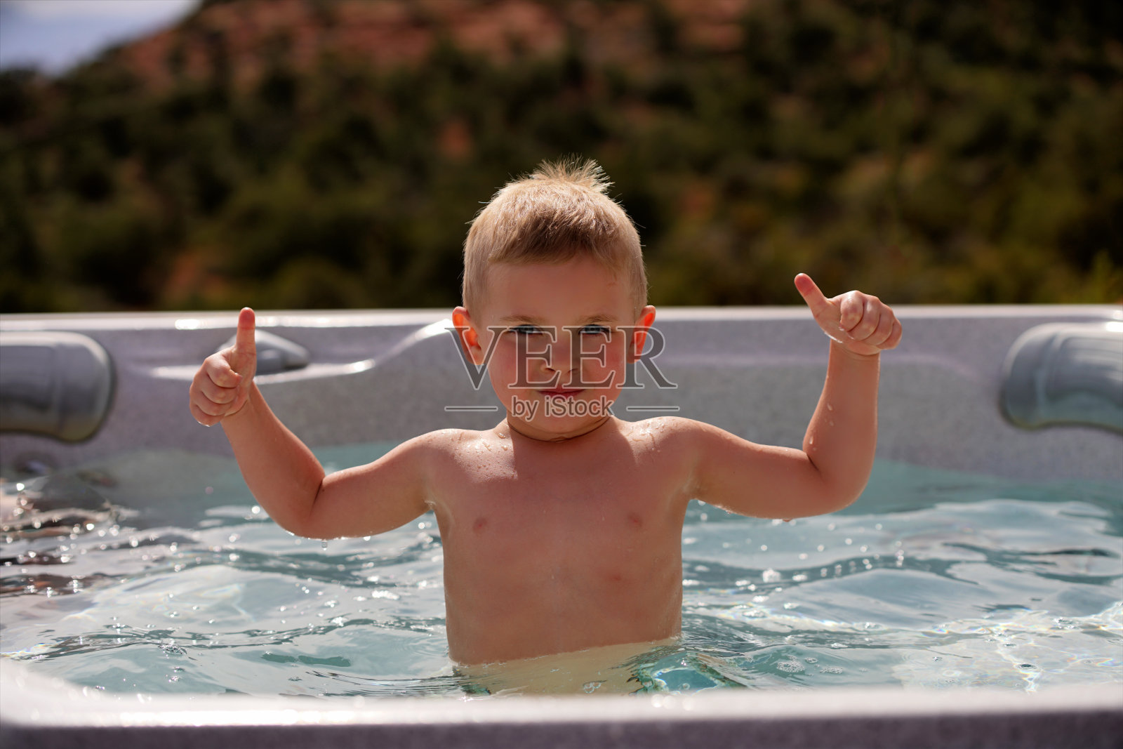 小男孩在浴缸里竖起大拇指照片摄影图片