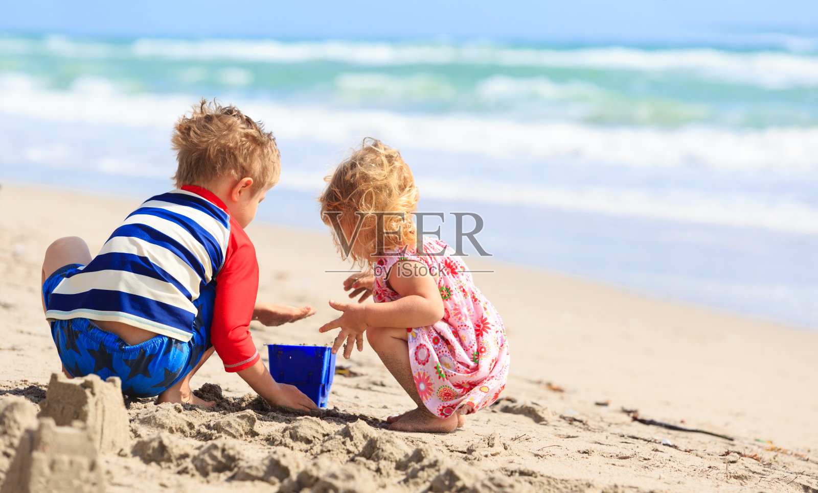 孩子们在夏天的海滩上玩沙子照片摄影图片