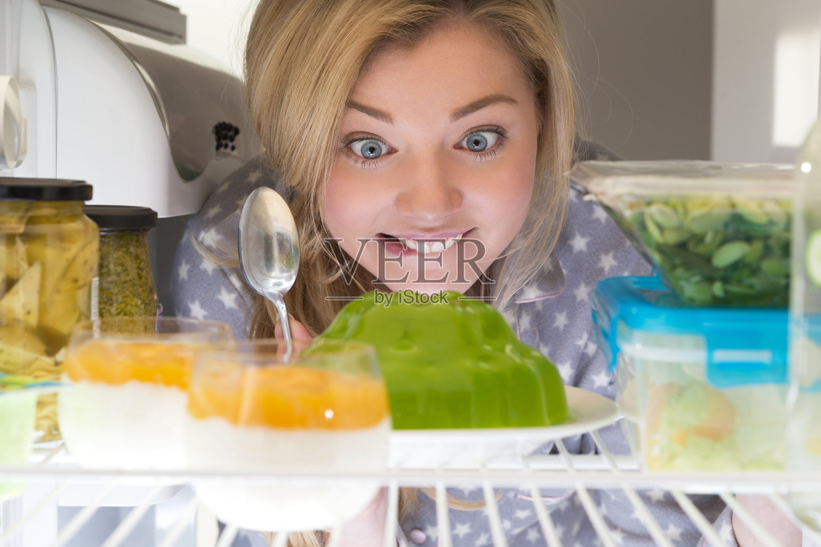 年轻女子用冰箱吃东西照片摄影图片
