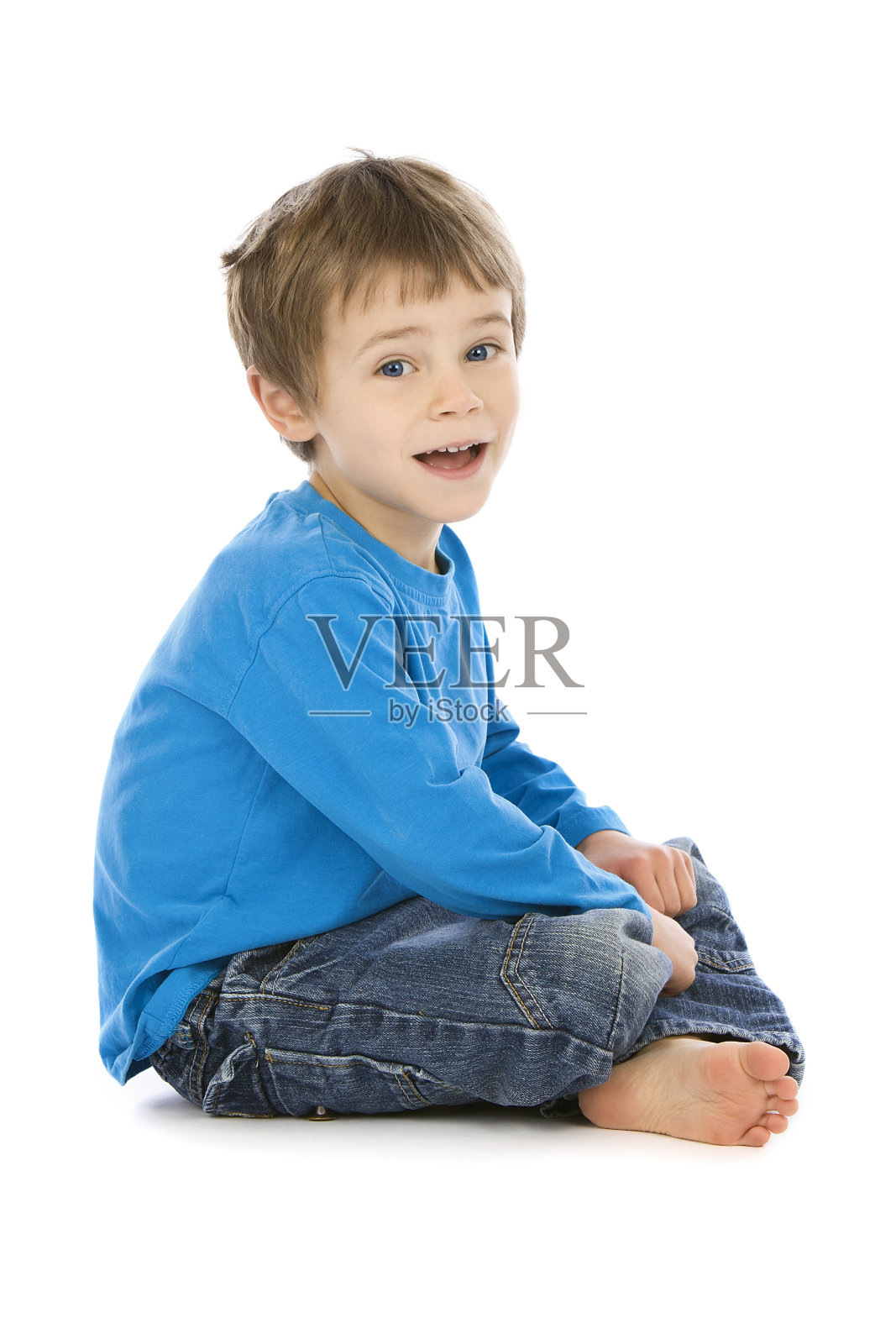 穿蓝色上衣的小男孩坐在白色的背景上照片摄影图片