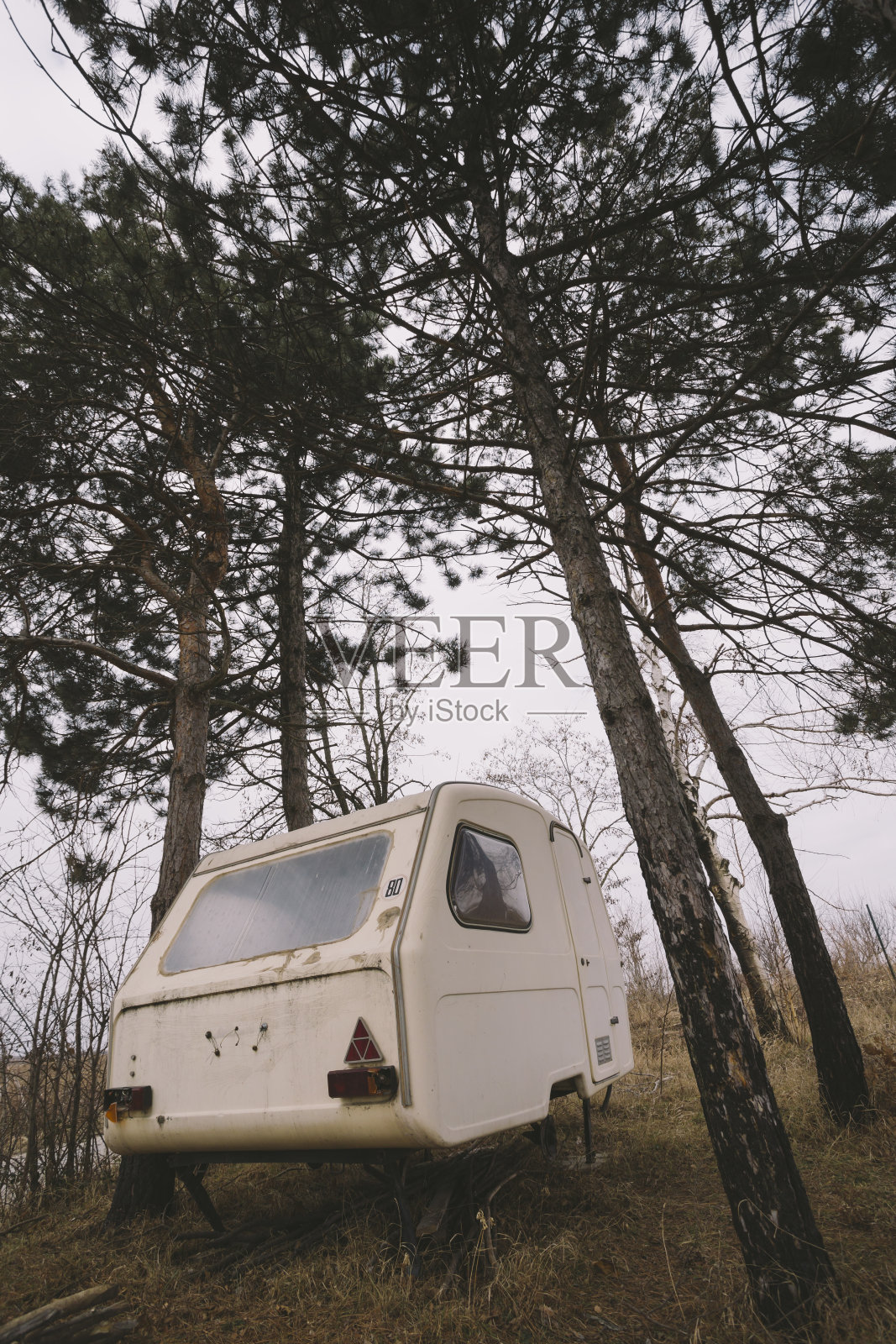 老旧的露营车停在树林里。低角度的观点。照片摄影图片