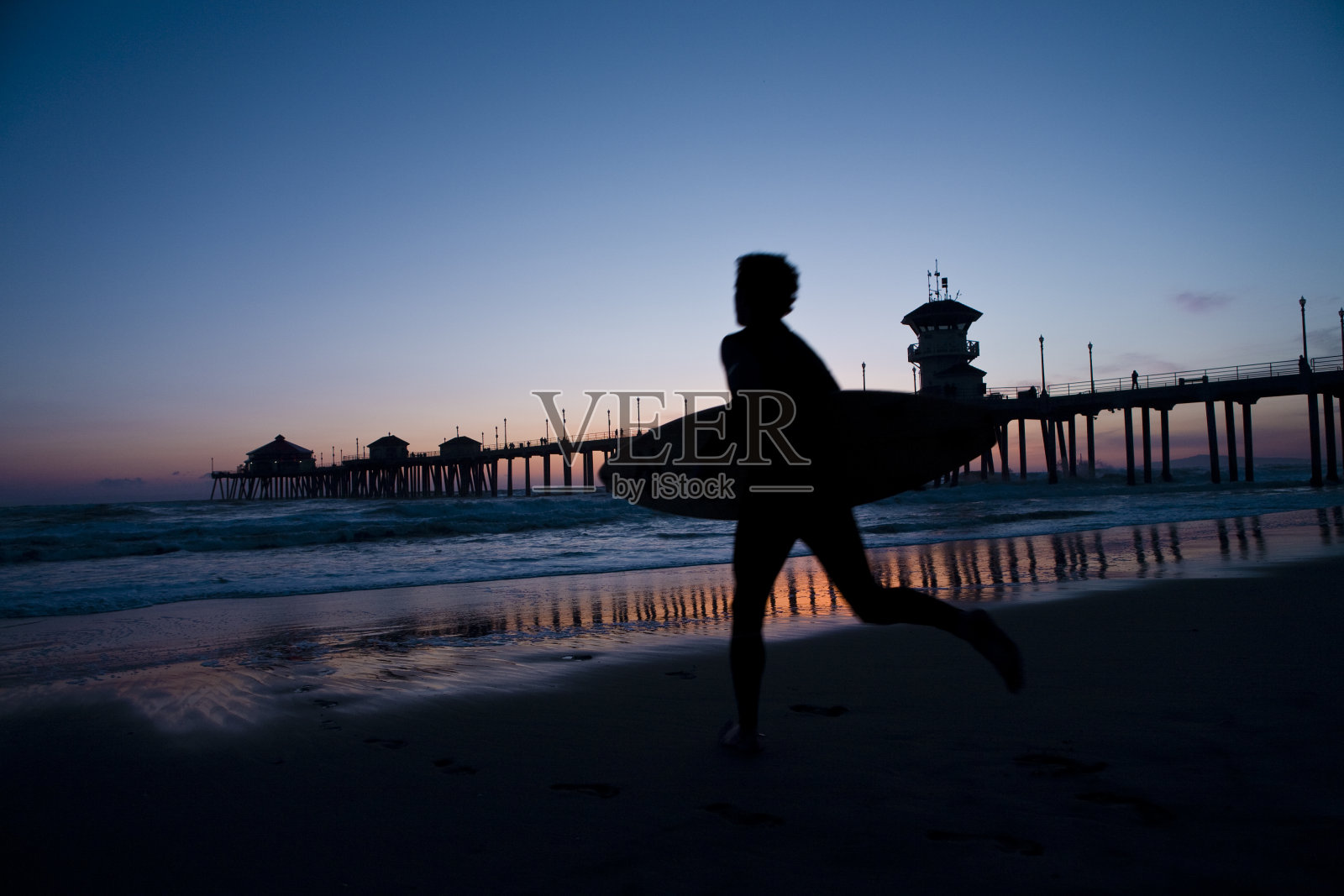 冲浪者在日落时分照片摄影图片