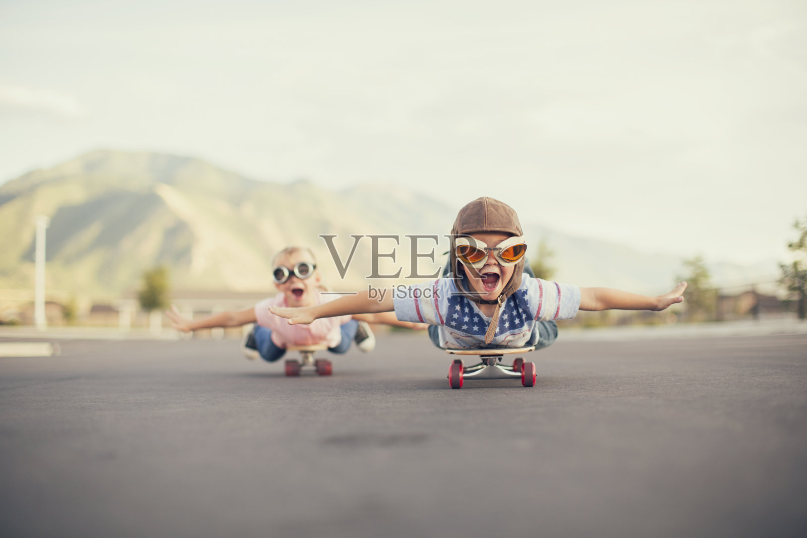 年轻的男孩和女孩想象在滑板上飞行照片摄影图片