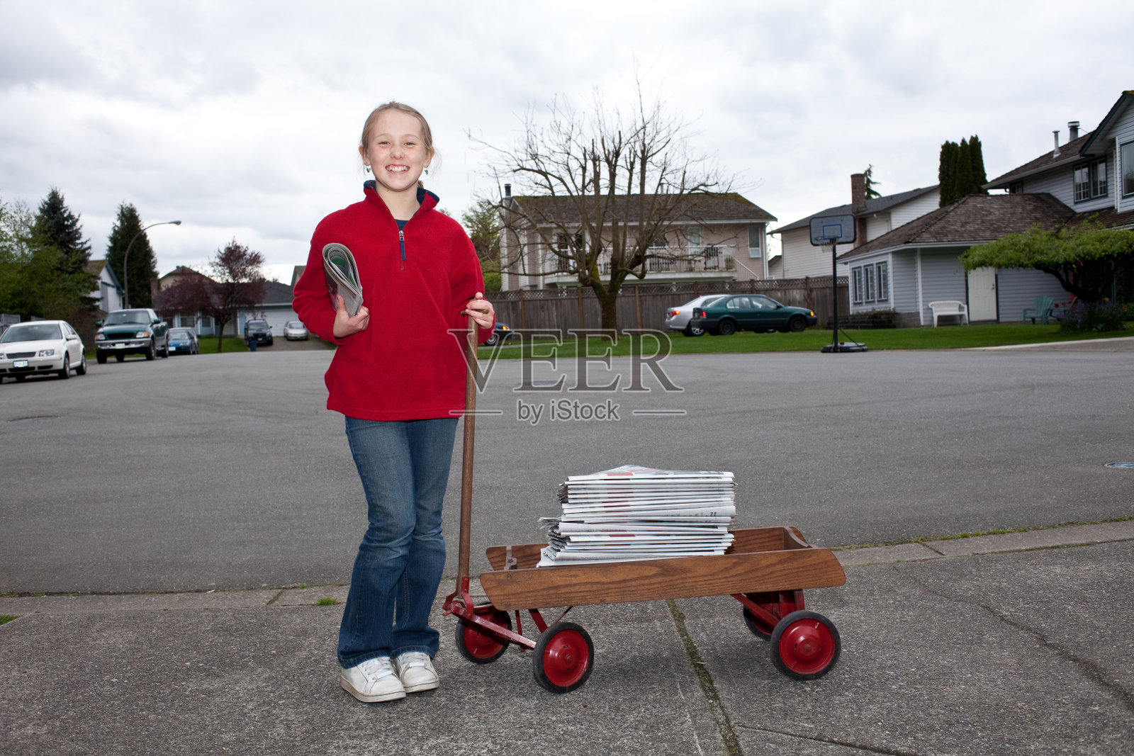 年轻的女孩在郊区附近用马车送报纸。照片摄影图片