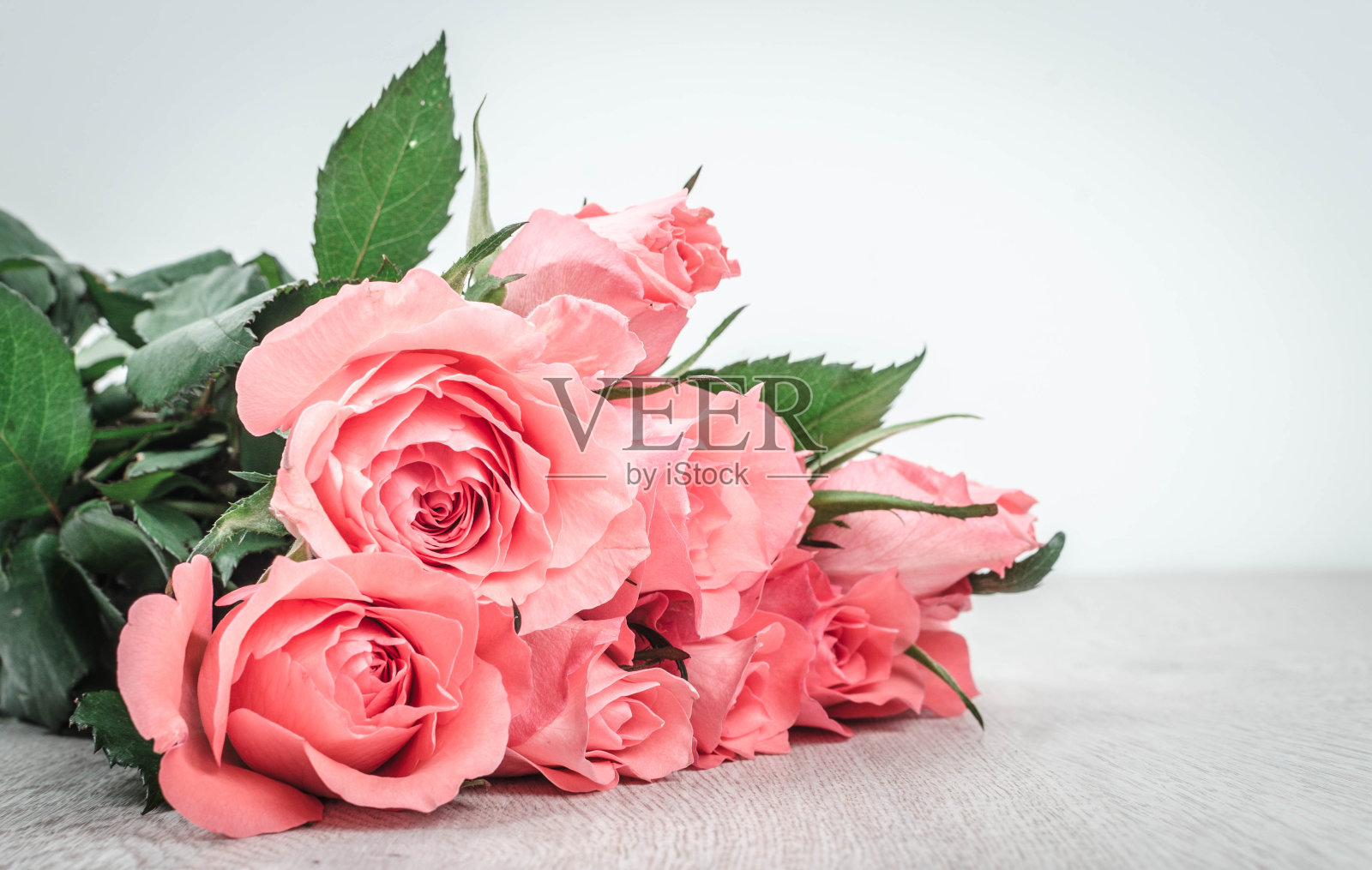 木桌上放着美妙的粉红玫瑰照片摄影图片