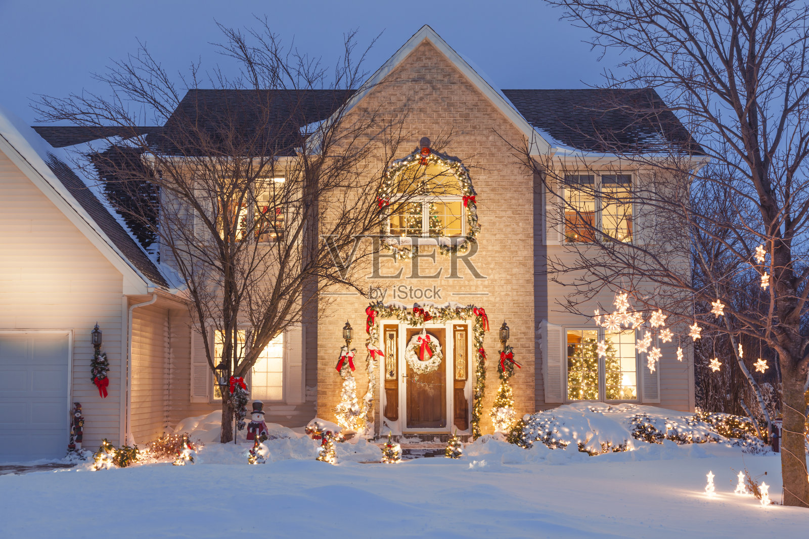 节日的圣诞家庭与假日照明，覆盖在雪照片摄影图片
