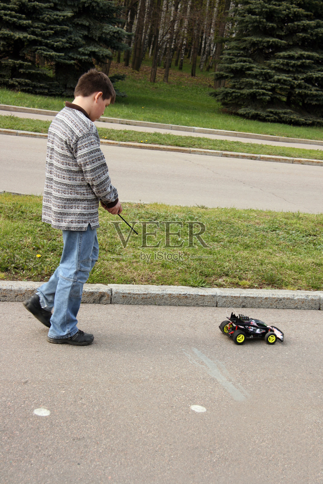 一个男生在公园里开着玩具车照片摄影图片