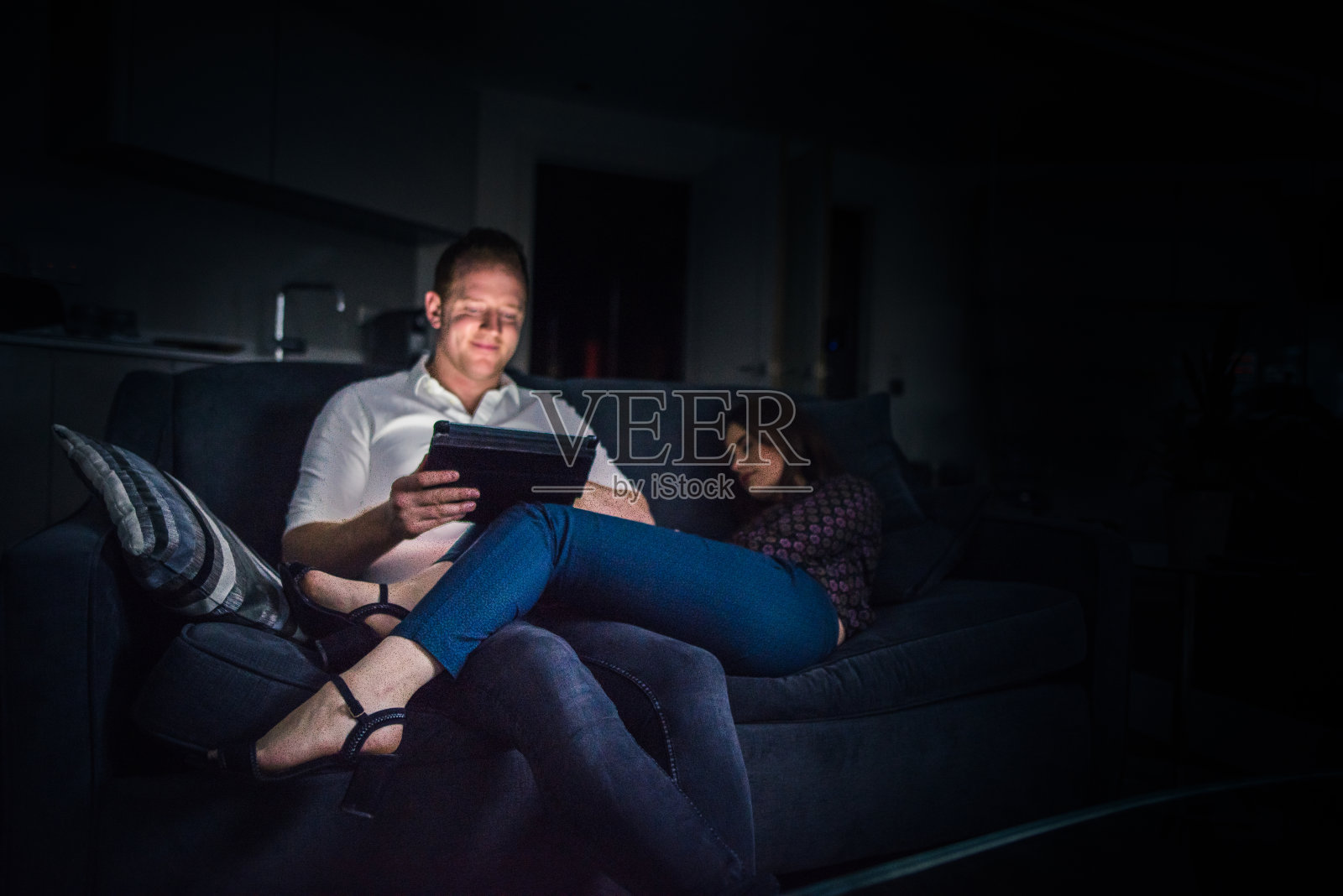 一对夫妇在家里的沙发上放松地使用平板电脑照片摄影图片